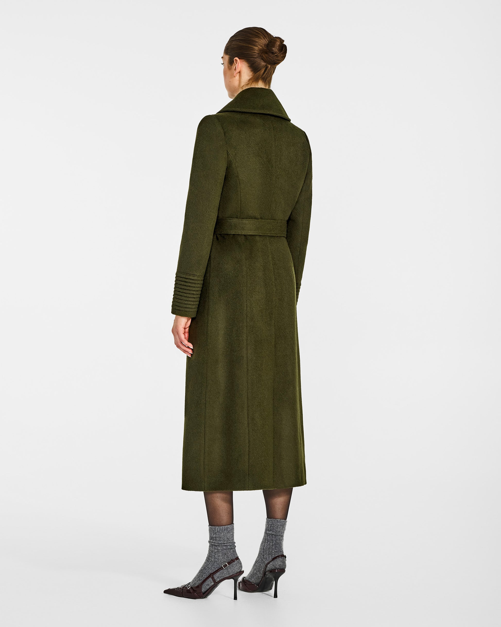 Back view of model wearing a SENTALER long olive green wrap coat made of baby alpaca wool, with a large notched collar, worn belted.