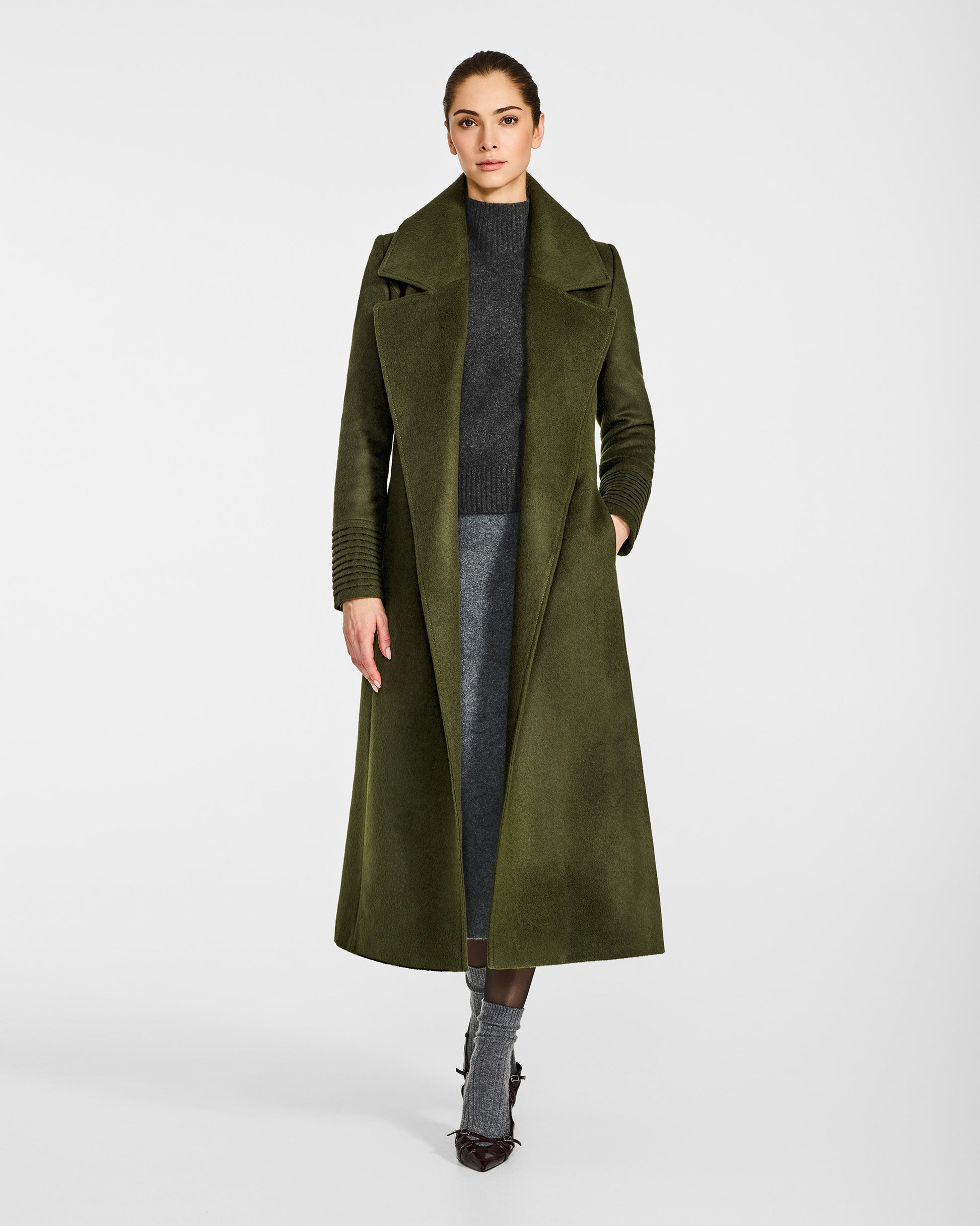 Front view of model wearing a SENTALER long olive green wrap coat made of baby alpaca wool, with a large notched collar, worn open.