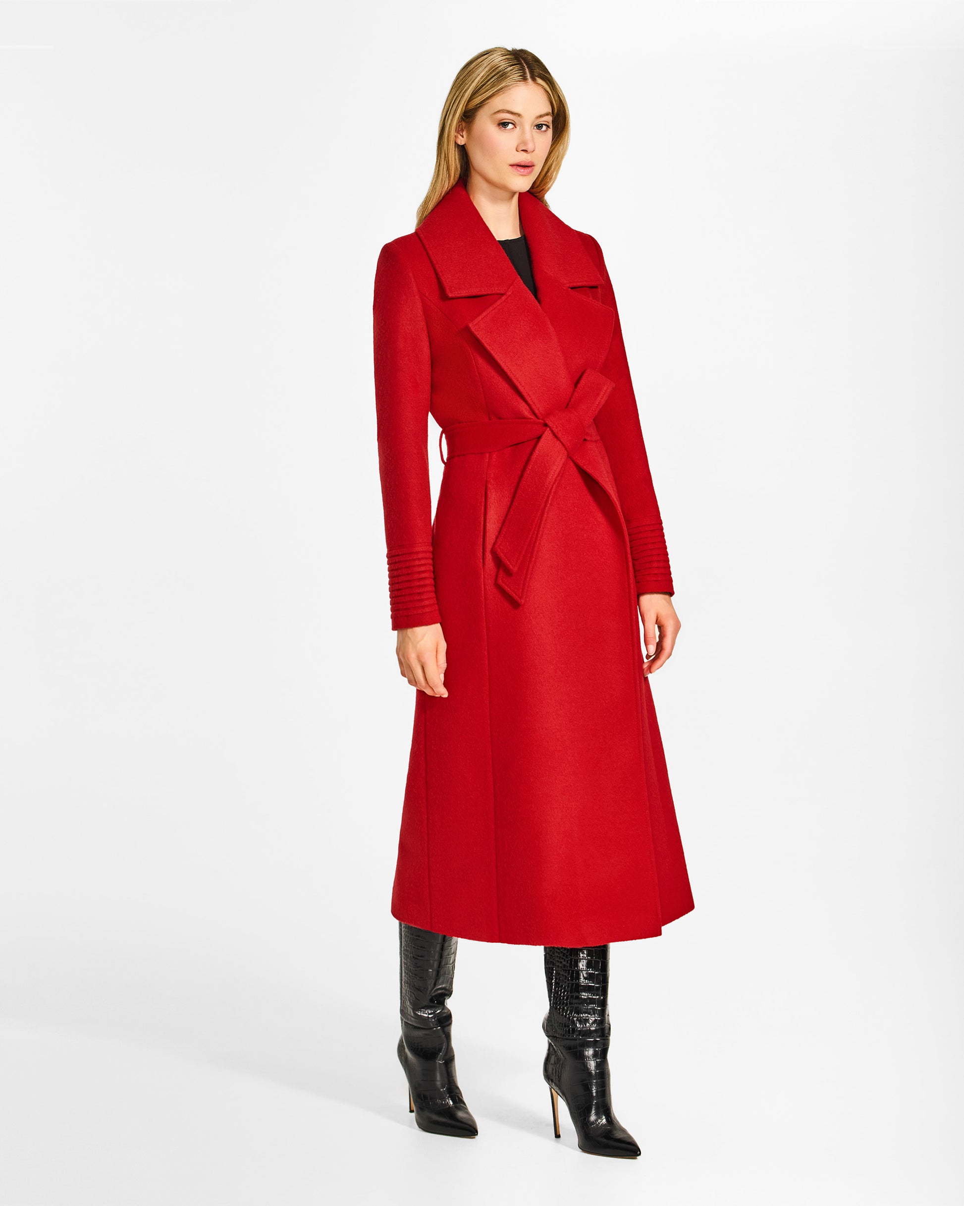 Side view of model wearing a SENTALER long scarlet red wrap coat made of baby alpaca wool, with a large notched collar, worn belted.