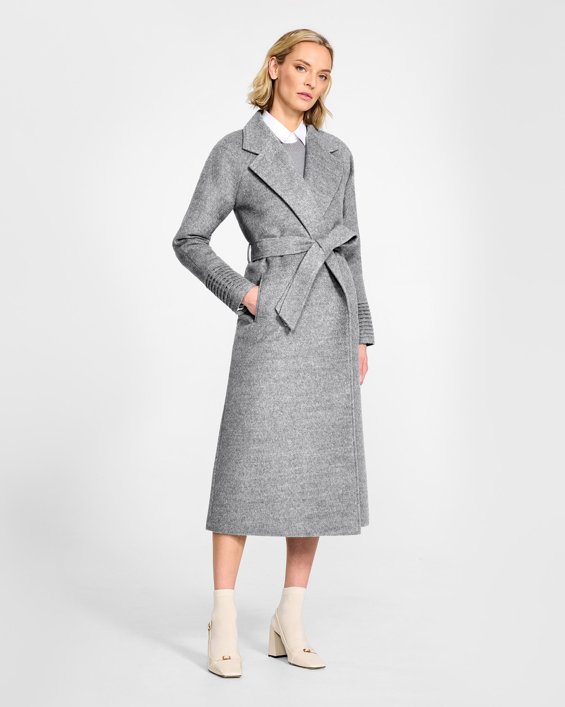 Front view of model wearing a SENTALER long shale grey wrap coat made of baby alpaca wool, with raglan sleeves, worn belted.