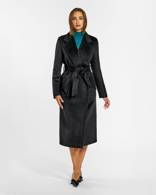 Front view of model wearing a Sentaler long black wrap coat made of baby alpaca wool, with a notched collar, worn belted.