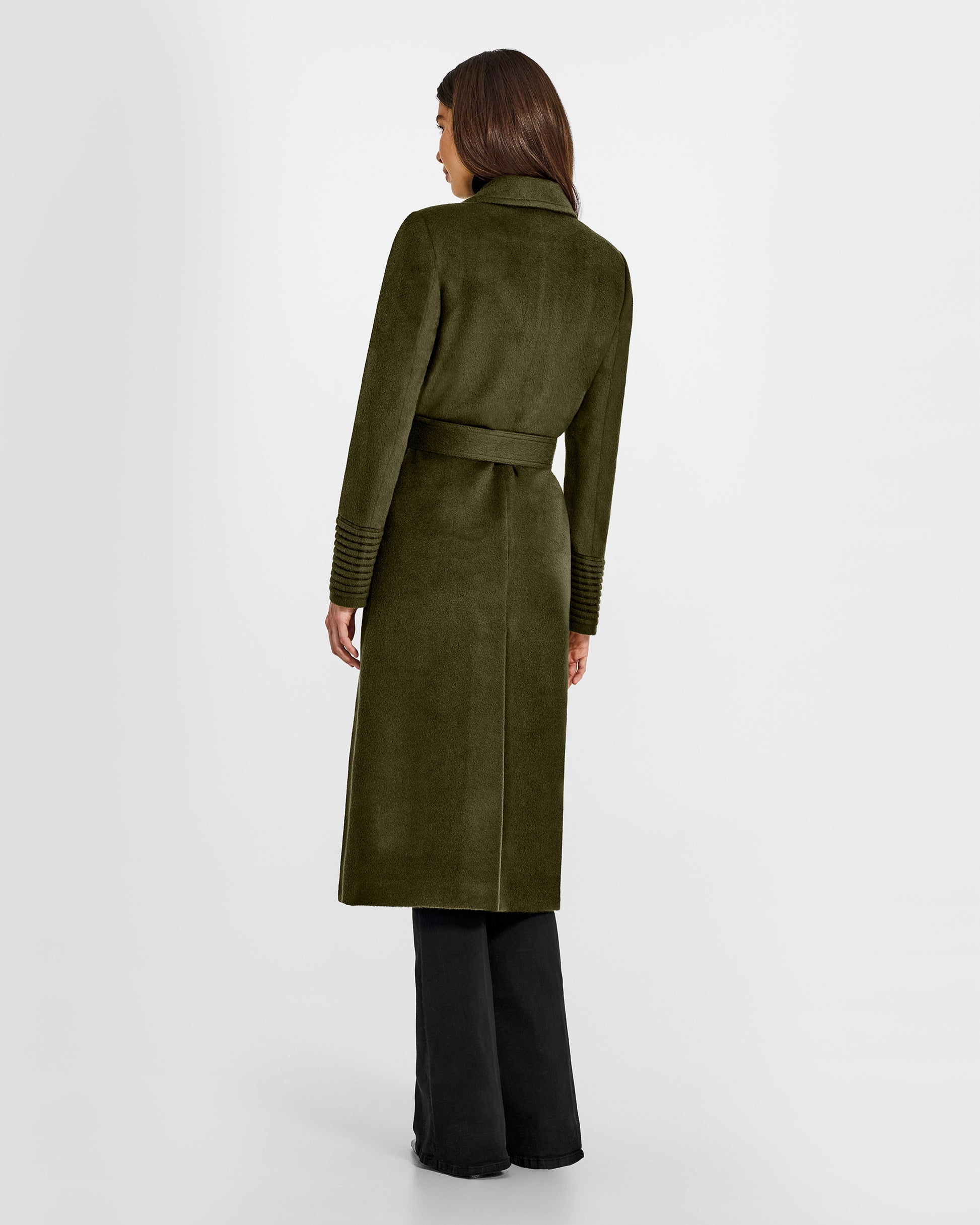 Back view of model wearing a Sentaler long olive green wrap coat made of baby alpaca wool, with a notched collar, worn belted.