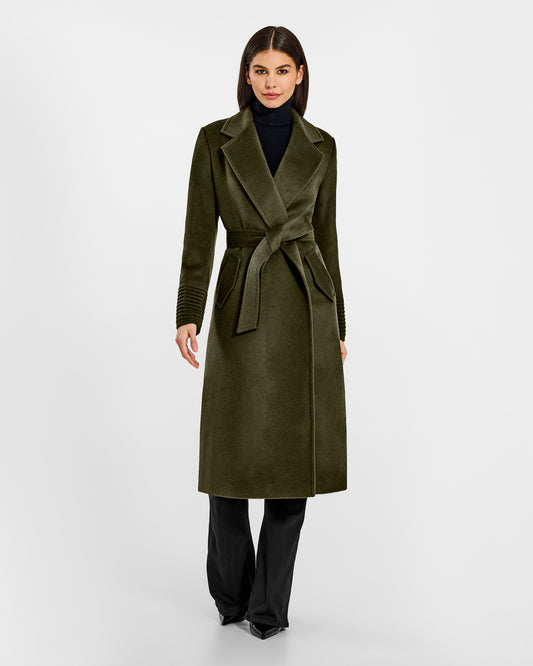 Front view of model wearing a Sentaler long olive green wrap coat made of baby alpaca wool, with a notched collar, worn belted.
