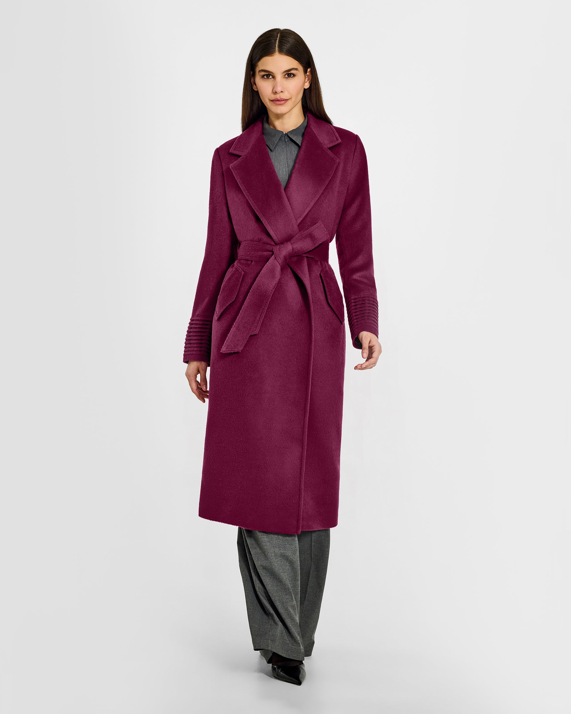 Front view of model wearing a Sentaler long plum berry purple wrap coat made of baby alpaca wool, with a notched collar, worn belted.