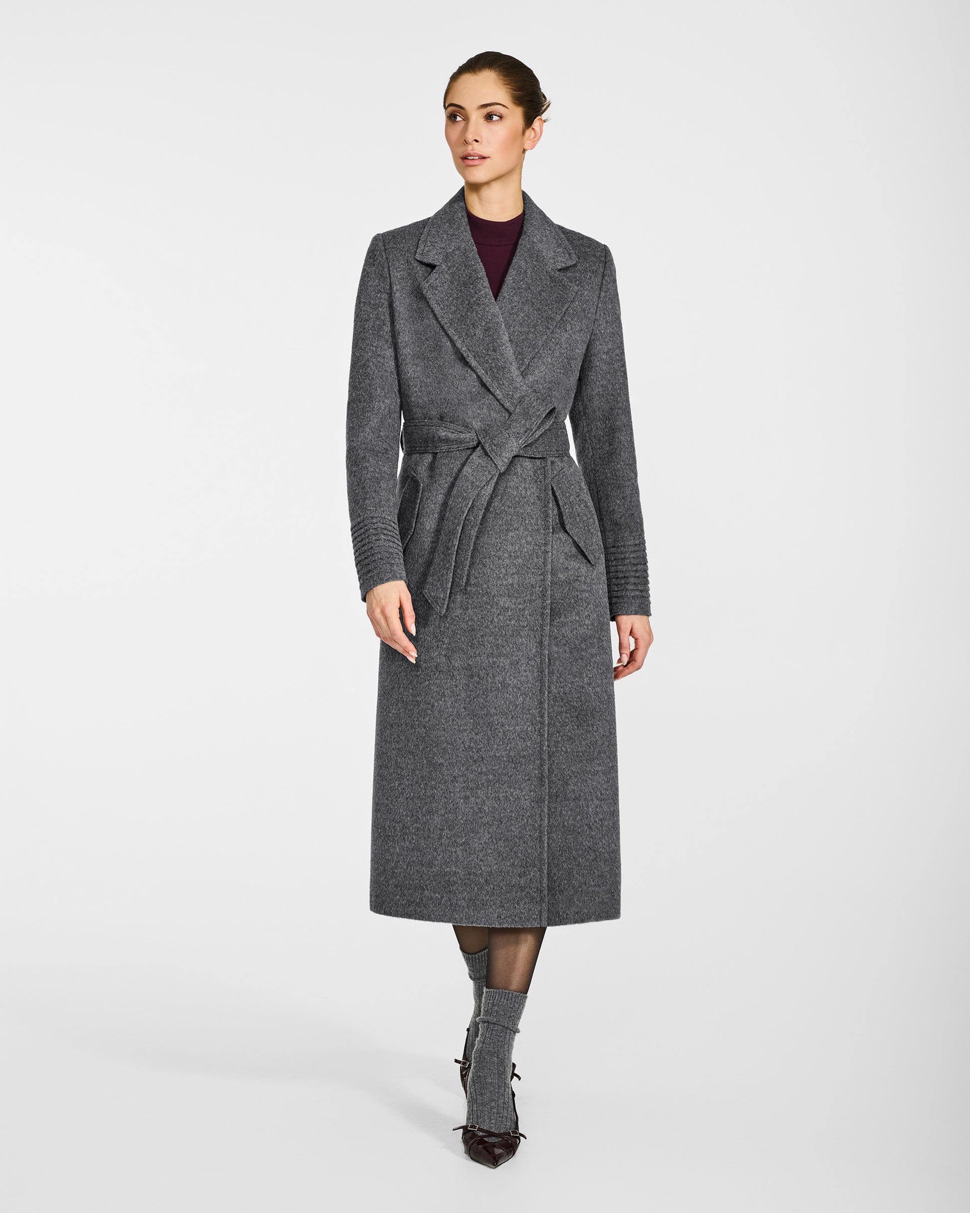 Front view of model wearing a Sentaler long grey mélange wrap coat made of baby alpaca wool, with a notched collar, worn belted.