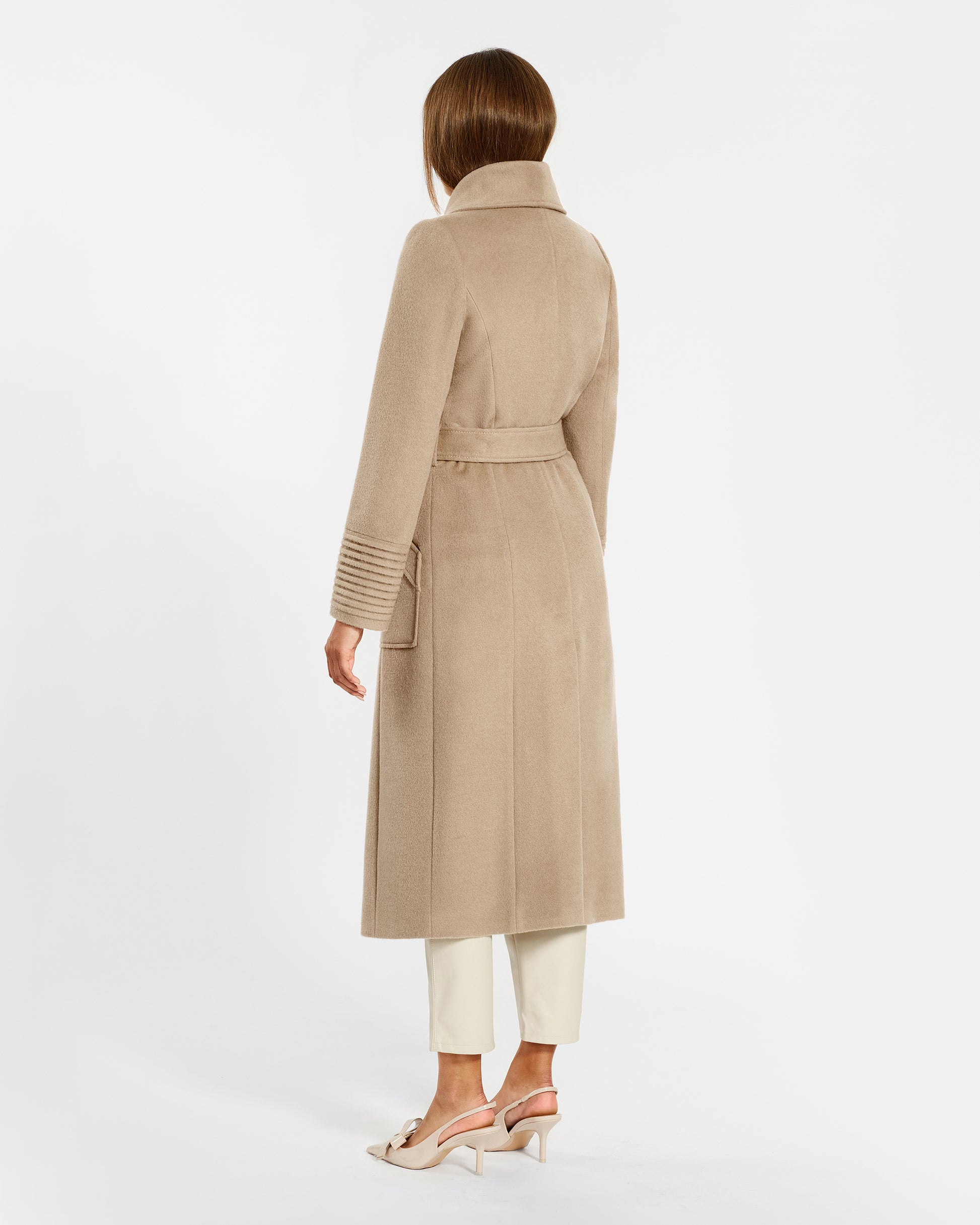 Backl view of model wearing a Sentaler camel long wrap coat made of baby alpaca wool, with a wide collar, worn belted.