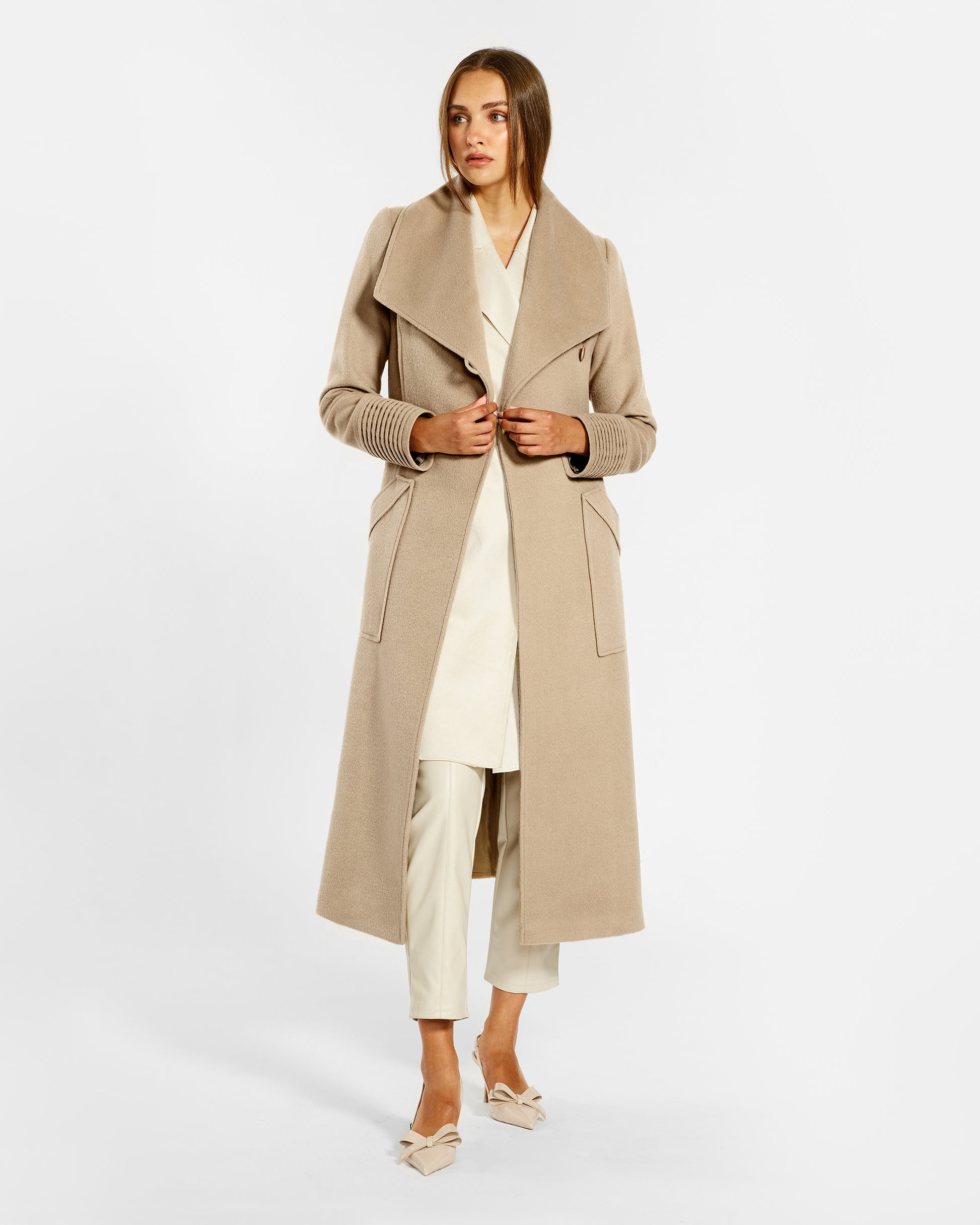 Front view of model wearing a Sentaler camel long wrap coat made of baby alpaca wool, with a wide collar, worn open.