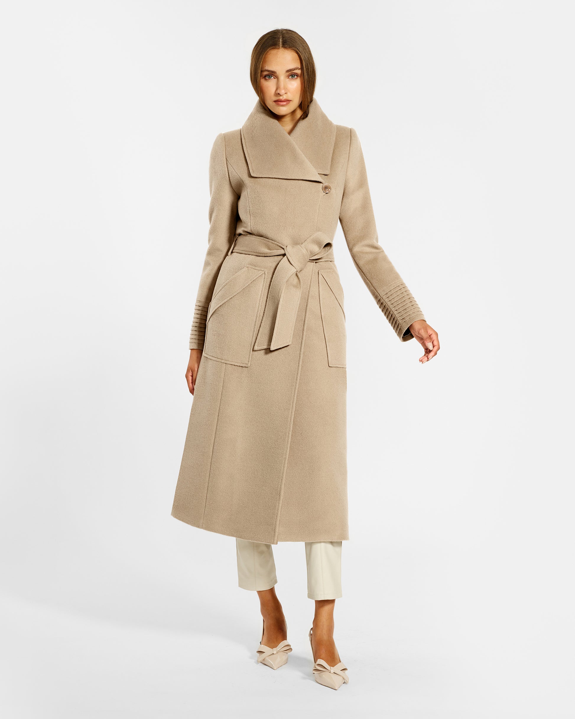 Front view of model wearing a Sentaler camel long wrap coat made of baby alpaca wool, with a wide collar, worn belted.