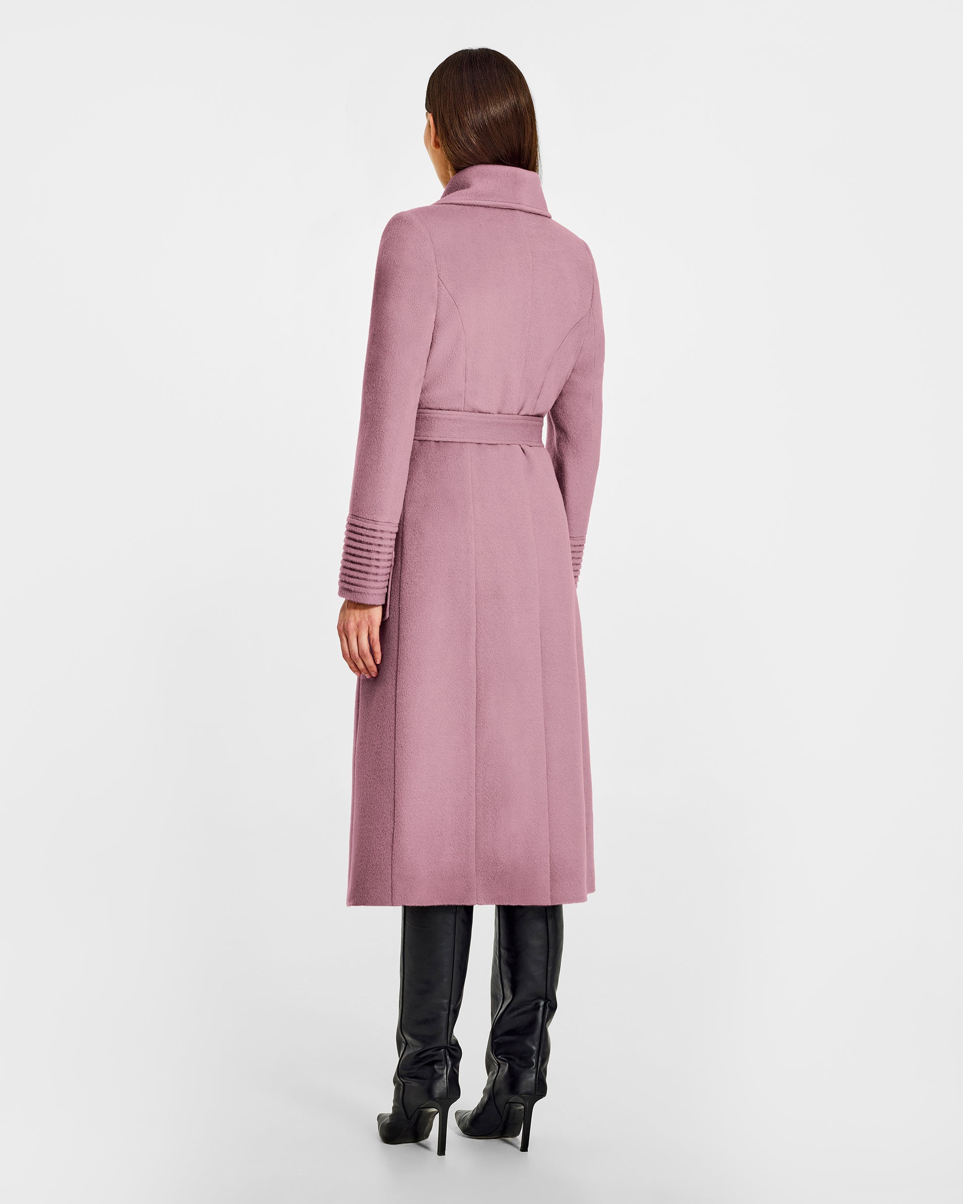 Back view of model wearing a Sentaler peony pink long wrap coat made of baby alpaca wool, with a wide collar, worn belted.