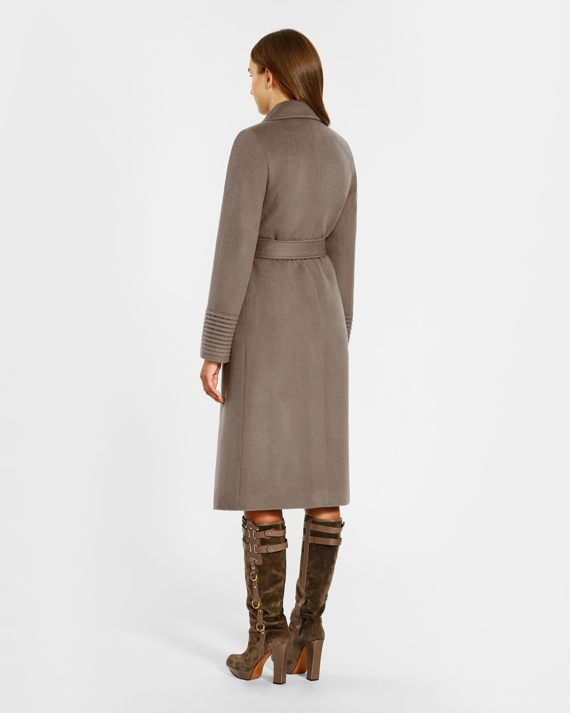 Back view of model wearing a Sentaler warm taupe long coat made of baby alpaca wool, with a wide notched collar, worn belted.