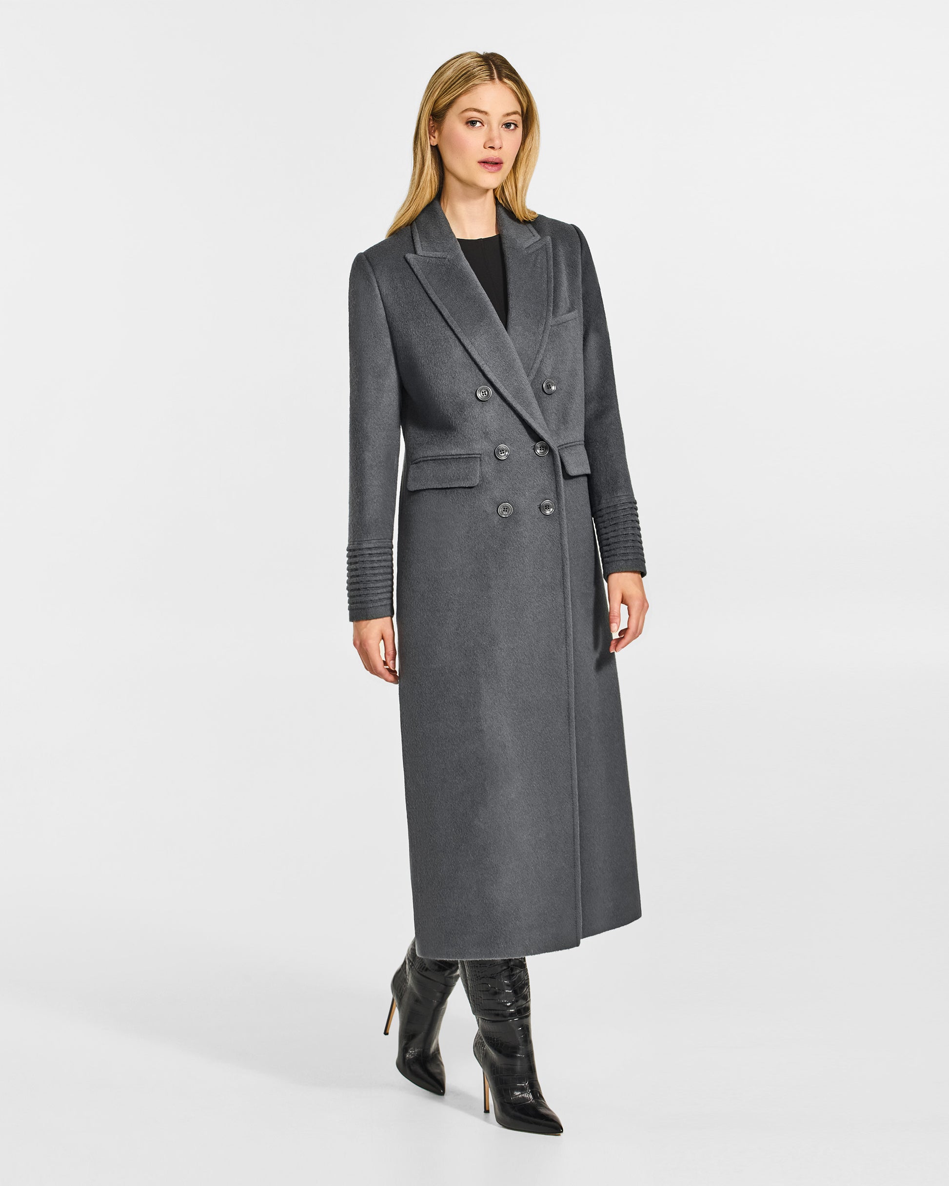 Side view of model wearing a Sentaler graphite grey double breasted maxi coat made of baby alpaca wool, with a peak collar, worn buttoned.