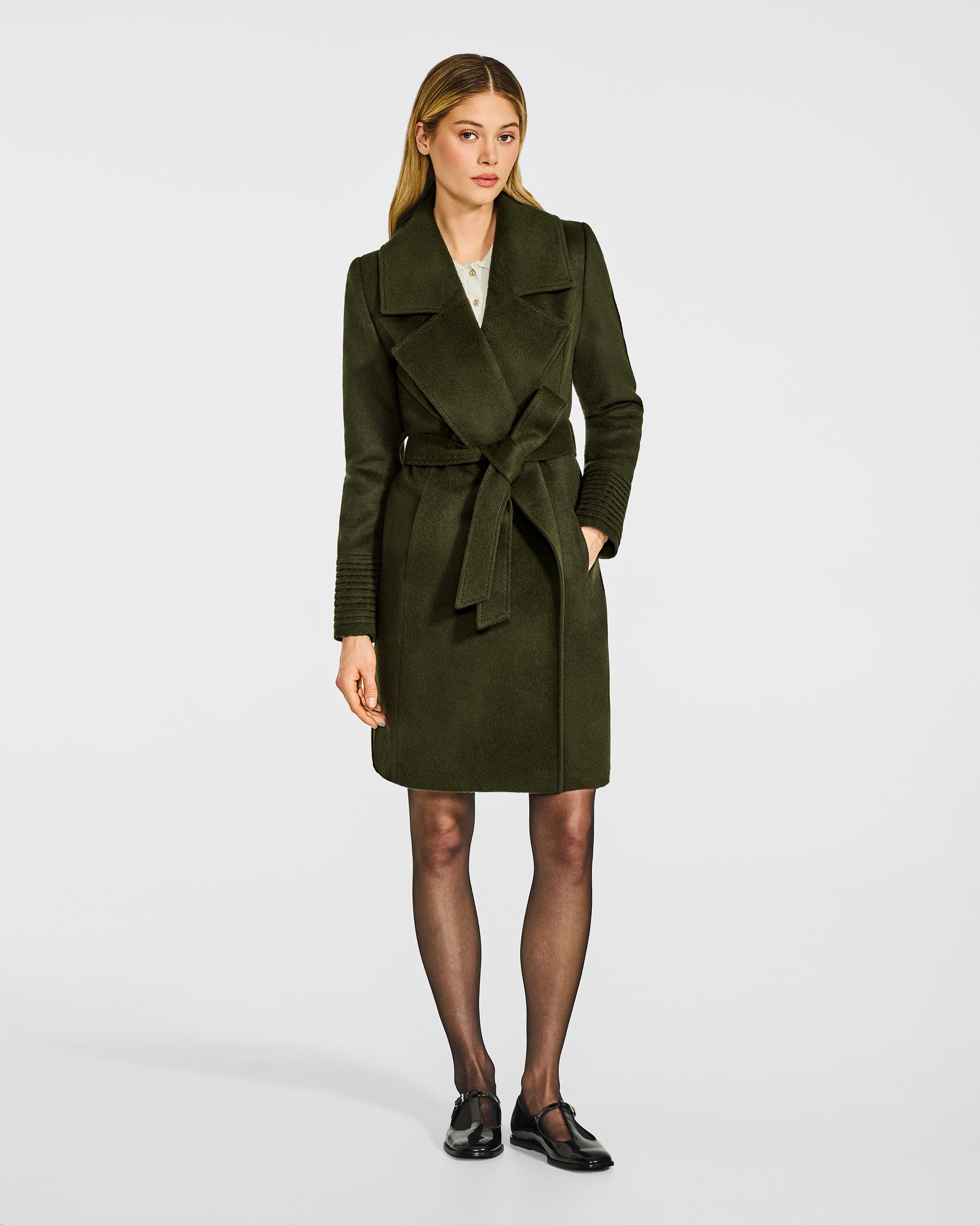 Front view of model in Sentaler mid length olive green coat with large notched collar in baby alpaca wool, belted.