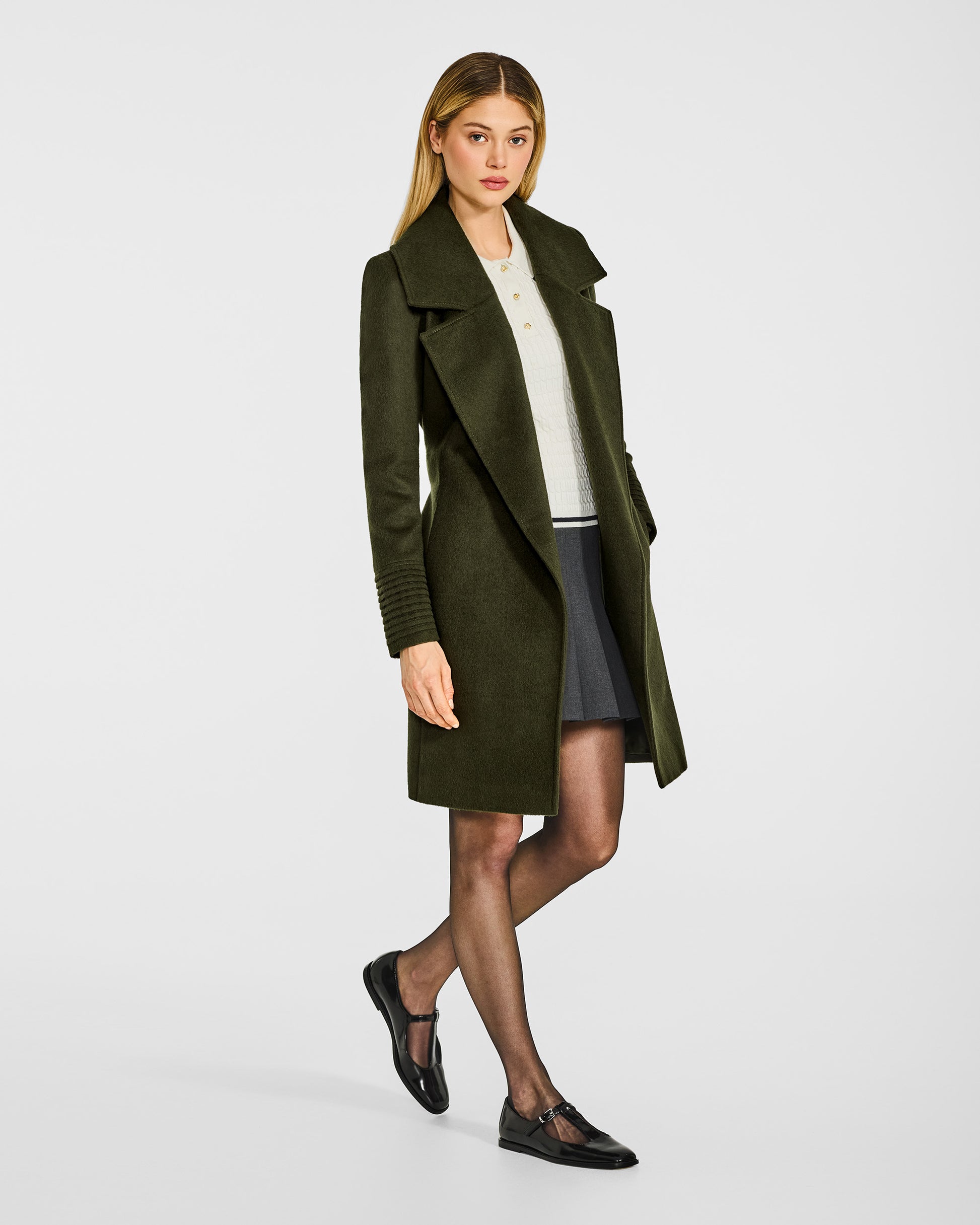 Side view of model in Sentaler mid length olive green coat with large notched collar in baby alpaca wool, open.