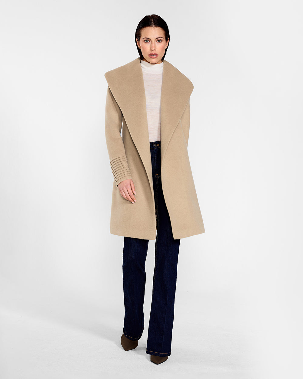 Front view of model wearing a Sentaler camel long wrap coat made of baby alpaca wool, with a wide collar, worn open.