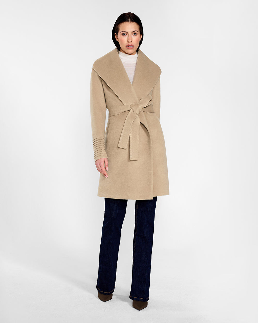 Front view of model wearing a Sentaler camel long wrap coat made of baby alpaca wool, with a wide collar, worn belted.