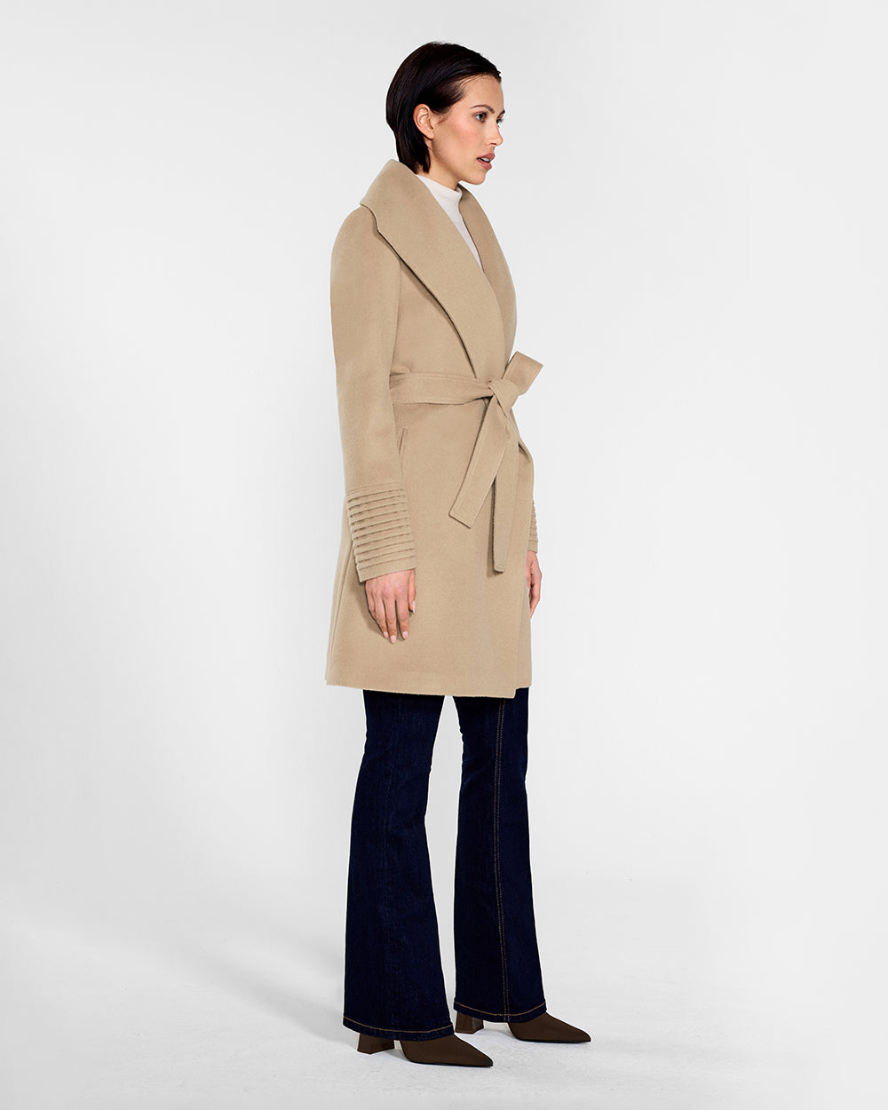 Side view of model wearing a Sentaler camel long wrap coat made of baby alpaca wool, with a wide collar, worn belted.