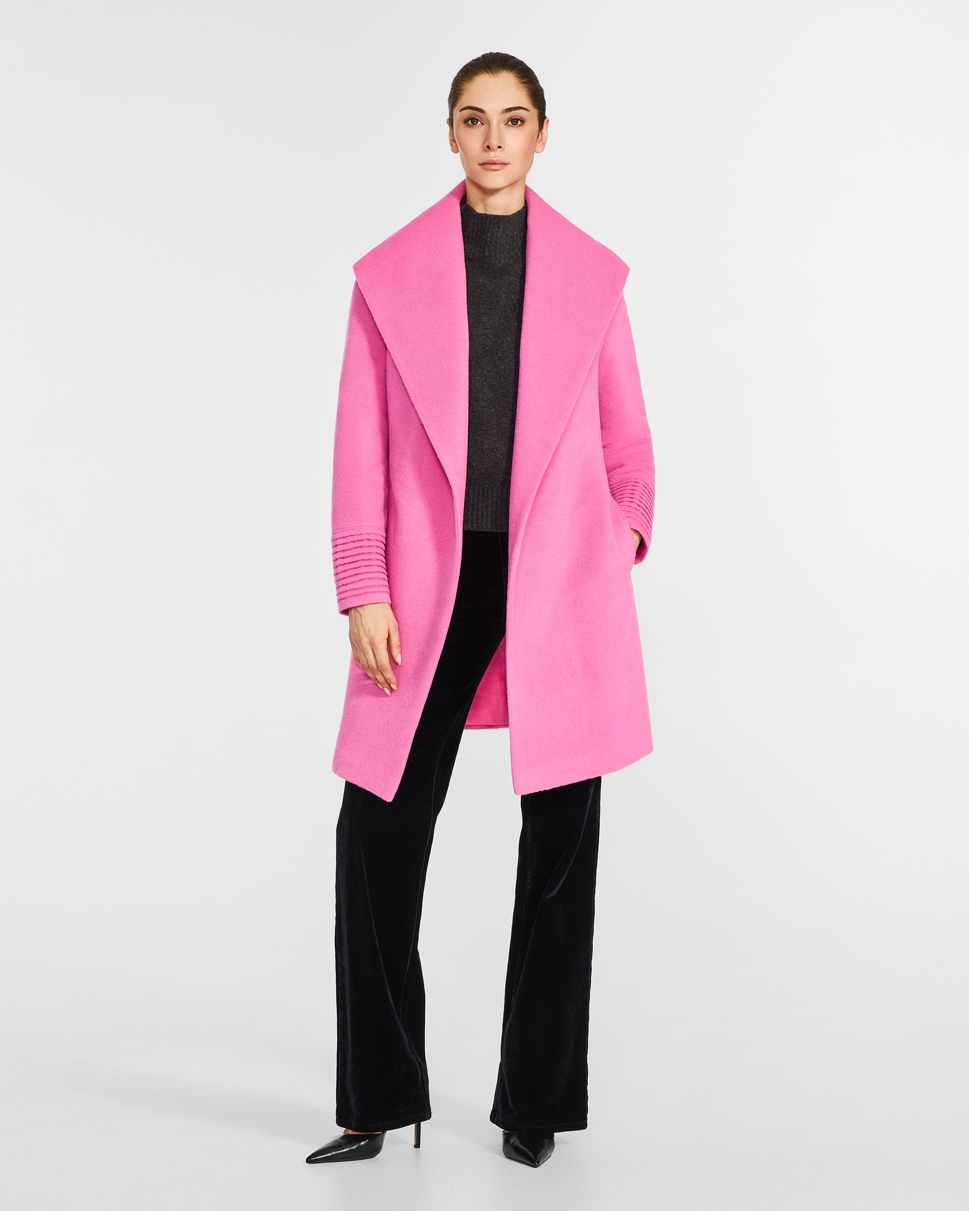 Front view of model wearing a Sentaler mid length cosmetic pink coat made of baby alpaca wool, with a shawl collar, worn open.