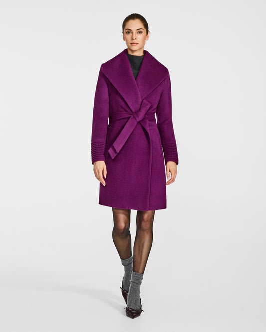 Front view of model wearing a Sentaler mid length dark mulberry purple coat made of baby alpaca wool, with a shawl collar, worn belted.