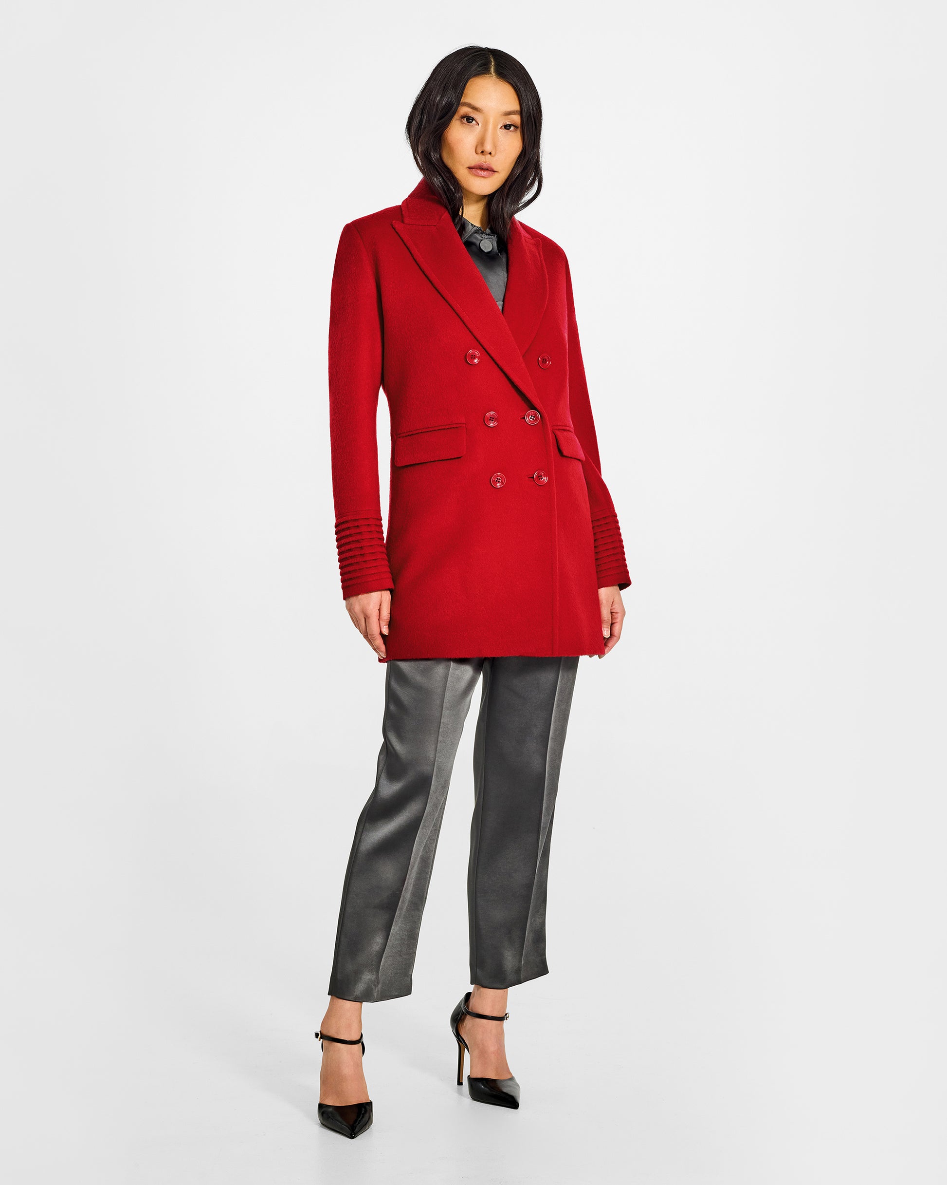 Front view of model wearing a Sentaler scarlet red topcoat made of baby alpaca wool, with a peak collar, worn buttoned.