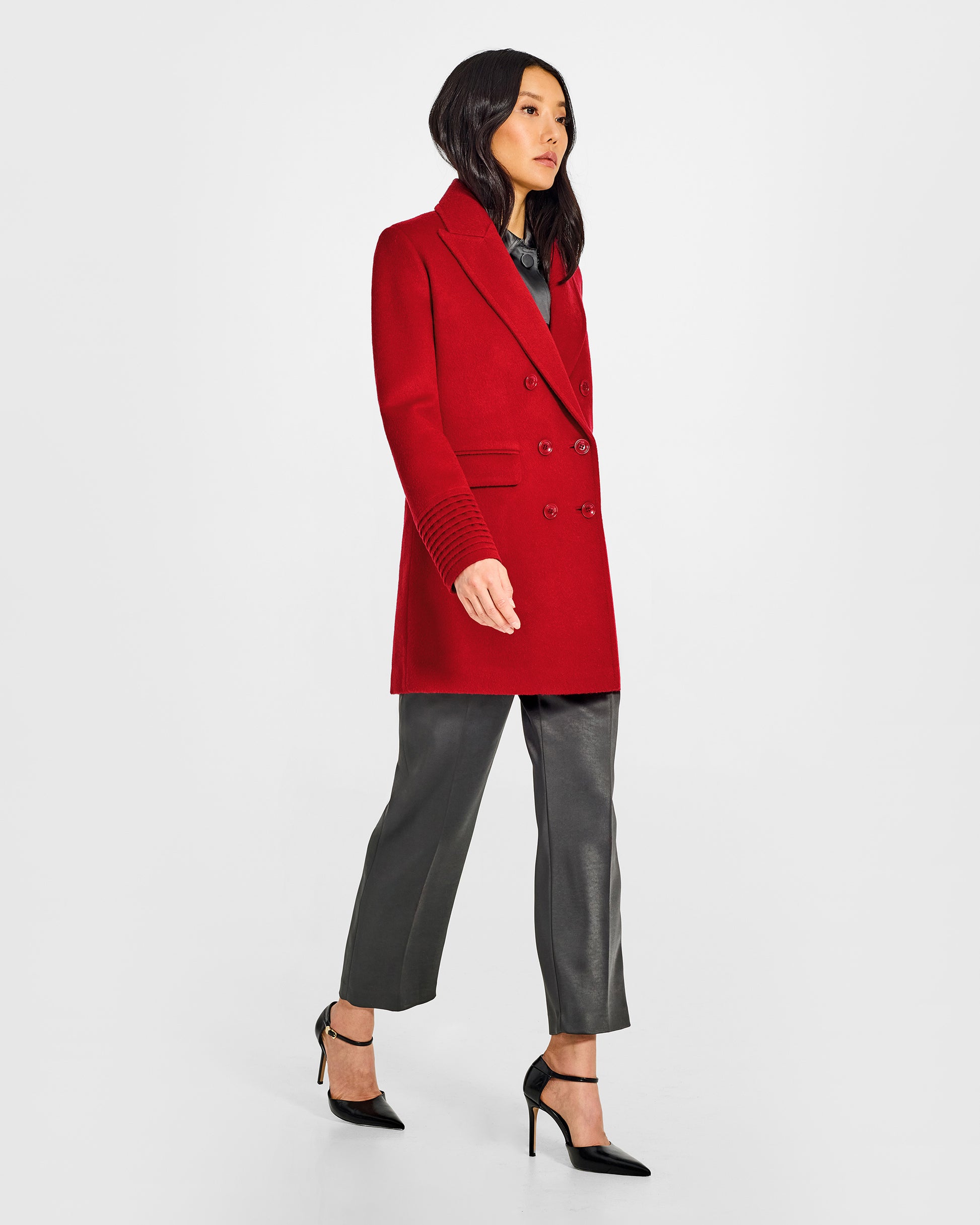 Side view of model wearing a Sentaler scarlet red topcoat made of baby alpaca wool, with a peak collar, worn buttoned.