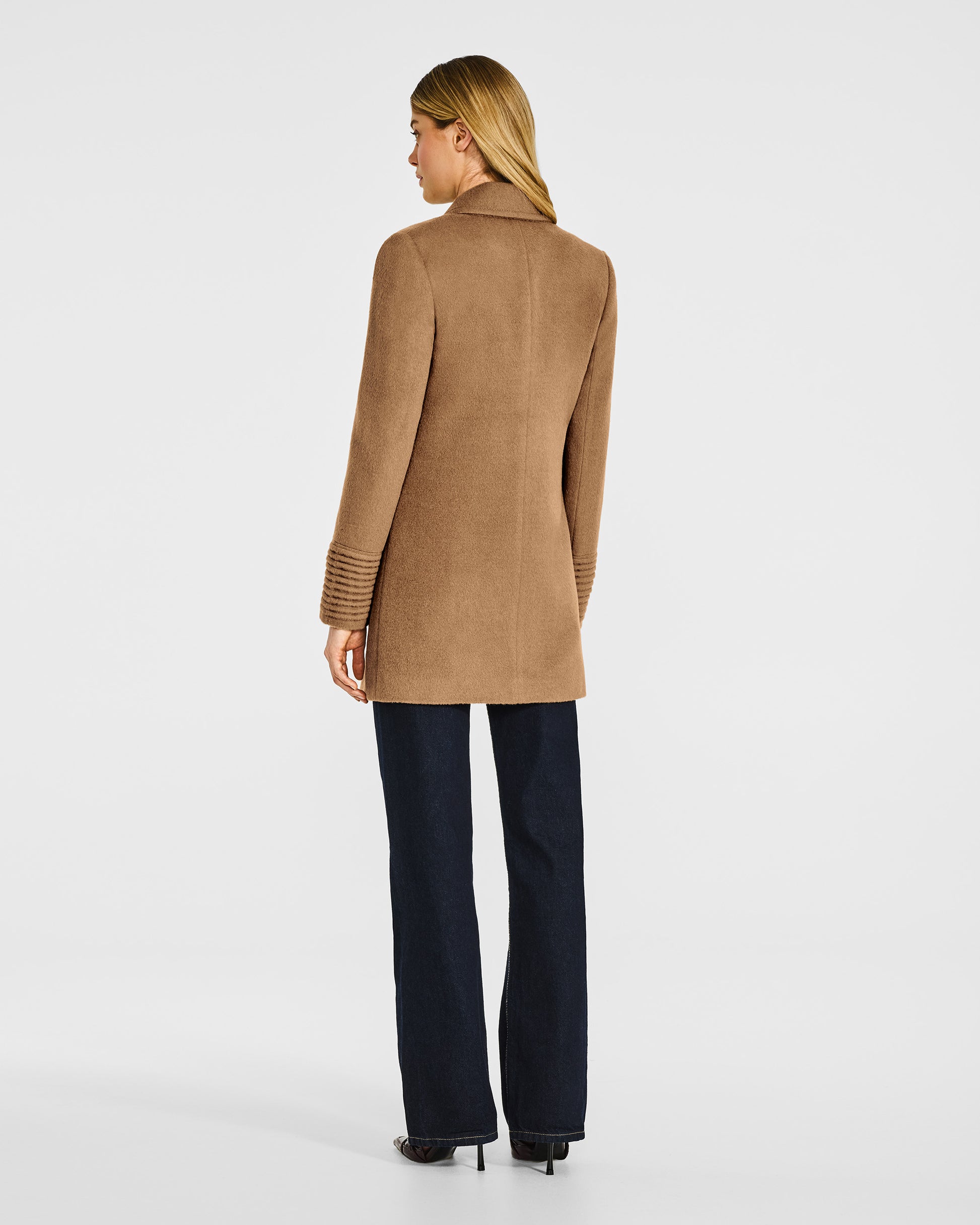 Back view of model in Sentaler dark camel topcoat with peak collar in baby alpaca wool, buttoned.