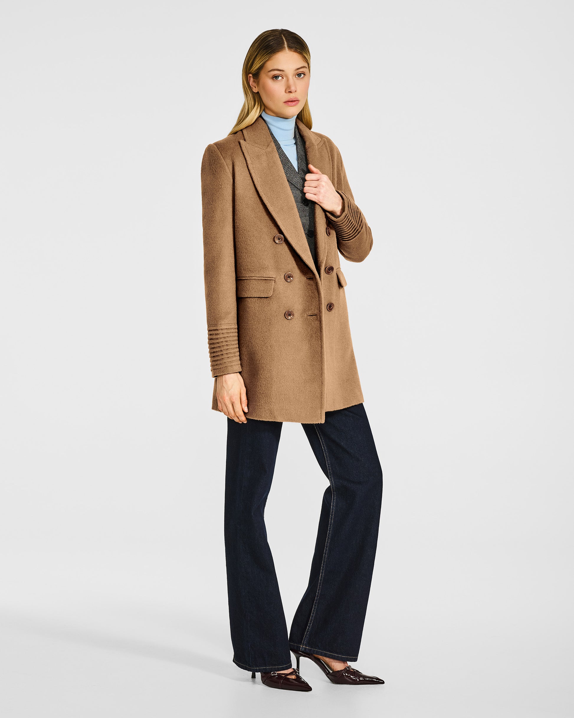 Side view of model in Sentaler dark camel topcoat with peak collar in baby alpaca wool, open.