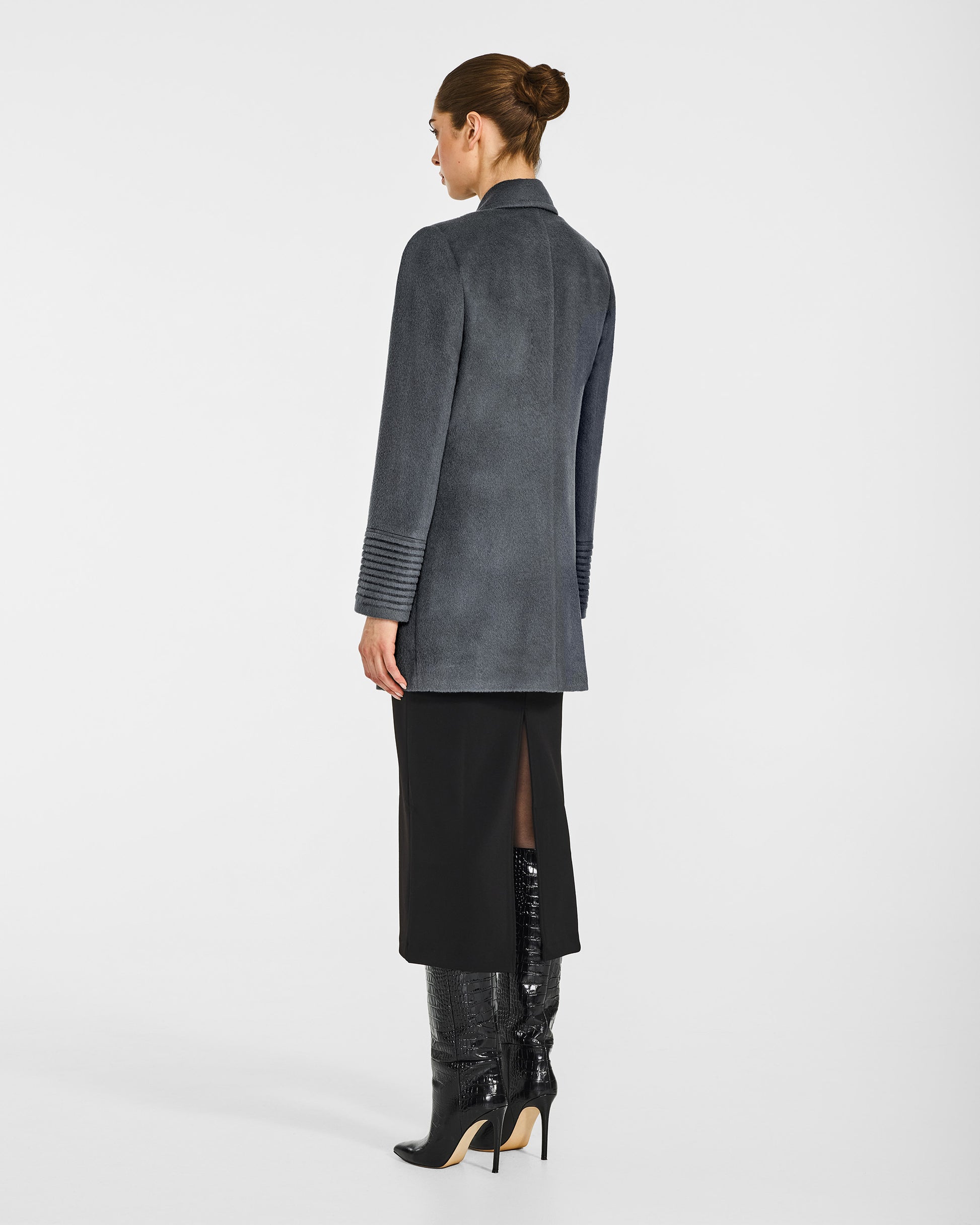 Back view of model in Sentaler graphite grey topcoat with peak collar in baby alpaca wool, buttoned.