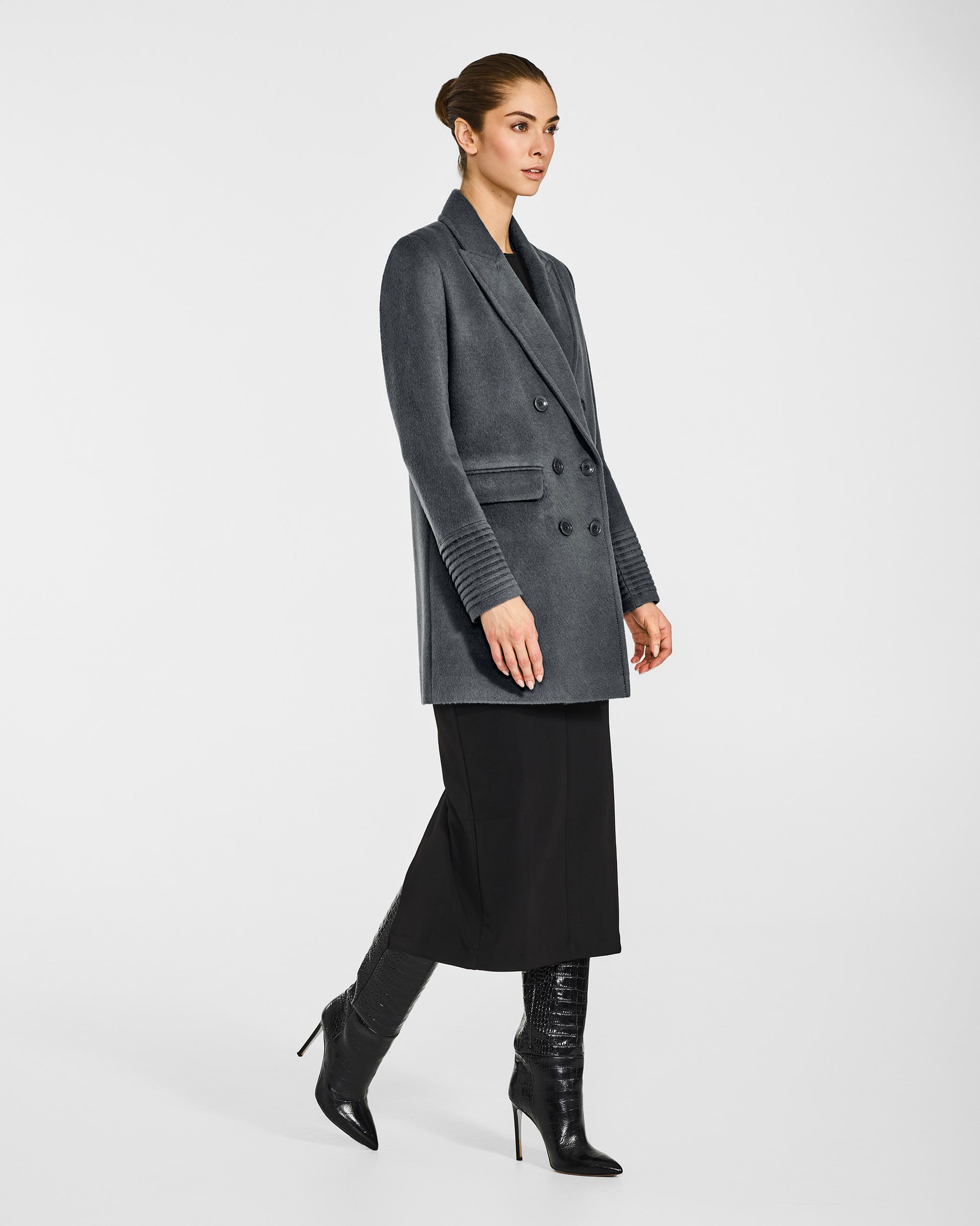 Side view of model in Sentaler graphite grey topcoat with peak collar in baby alpaca wool, buttoned.