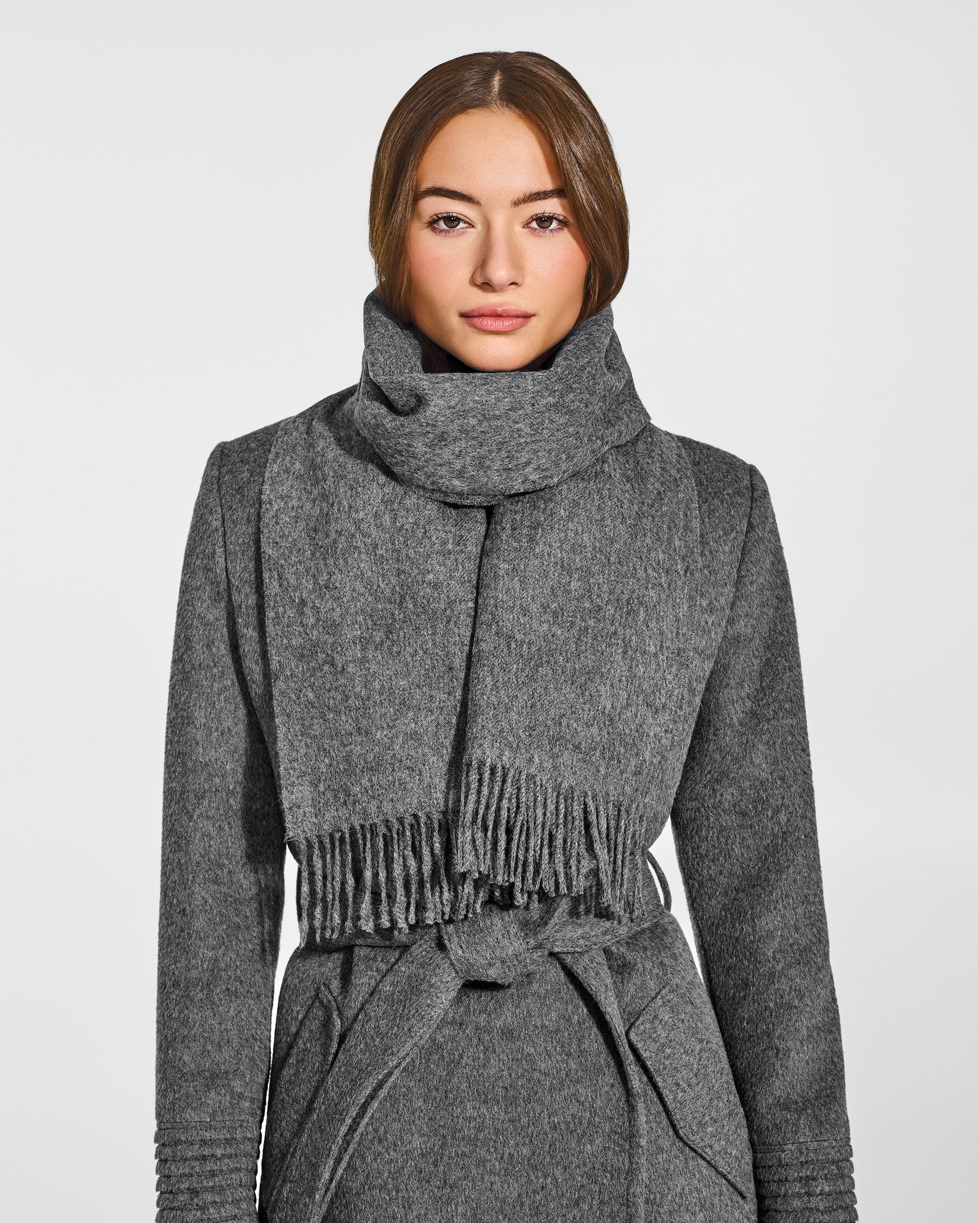 Front close-up view of model wearing Sentaler's adult Grey Mélange classic scarf, made of baby alpaca yarn. 