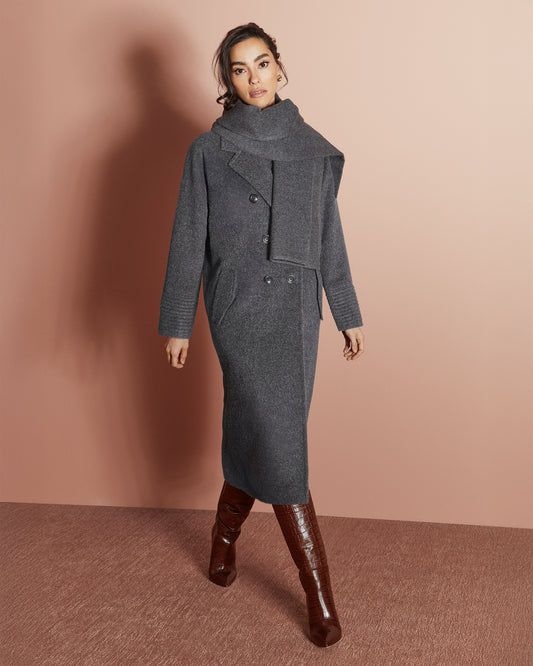 Front view of model wearing a Sentaler grey mélange double breasted coat made of baby alpaca wool with a notched collar, worn with fabric scarf, buttoned.
