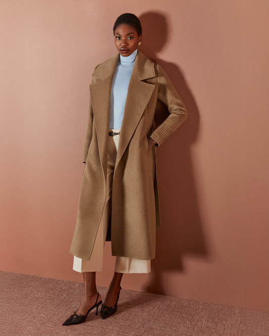 Front view of model wearing a SENTALER long dark camel wrap coat made of baby alpaca wool, with a large notched collar, worn open.