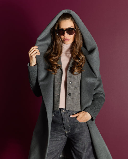 Front view of model wearing a Sentaler mid length graphite coat made of baby alpaca wool, with a hooded collar, worn open.