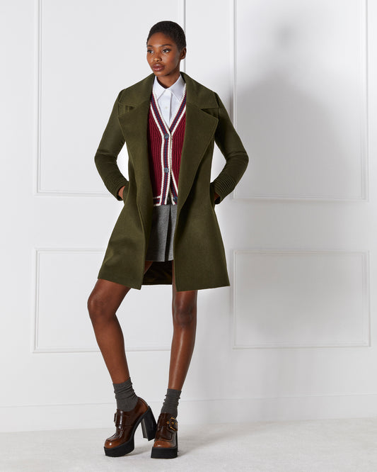Front view of model wearing a Sentaler mid length olive coat made of baby alpaca wool, with a large notched collar, worn open.
