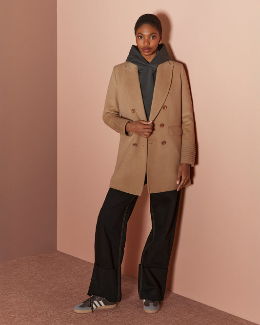 Front view of model wearing a Sentaler dark camel topcoat made of baby alpaca wool, with a peak collar, worn open.