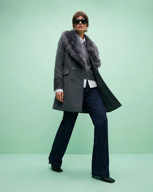 Front view of model wearing a Sentaler graphite topcoat made of baby alpaca wool, with a peak collar, worn unbuttoned with shearling collar in hand.