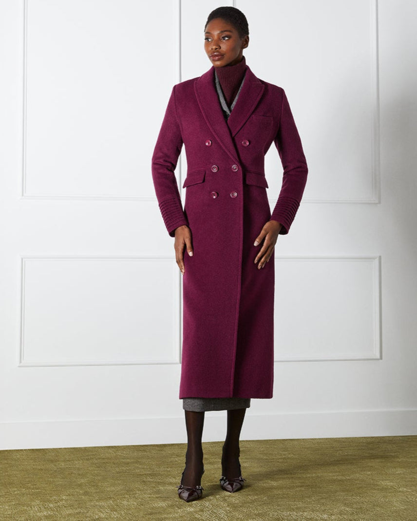 Front view of model wearing a Sentaler cherry lacquer double breasted maxi coat made of baby alpaca wool, with a peak collar, worn closed.