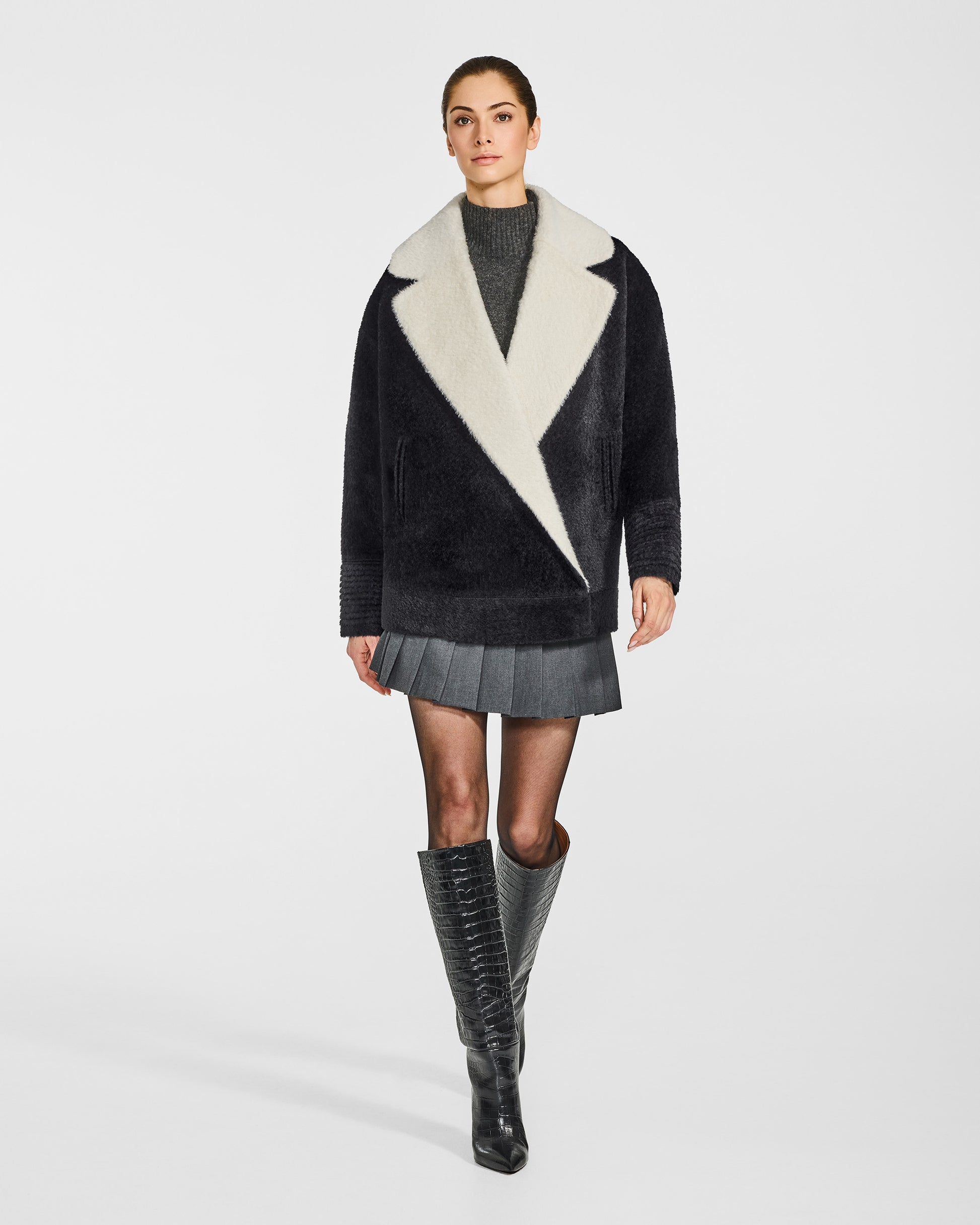 Front view of model in Sentaler black and white aviator jacket with dropped shoulders in bouclé alpaca wool, buttoned.