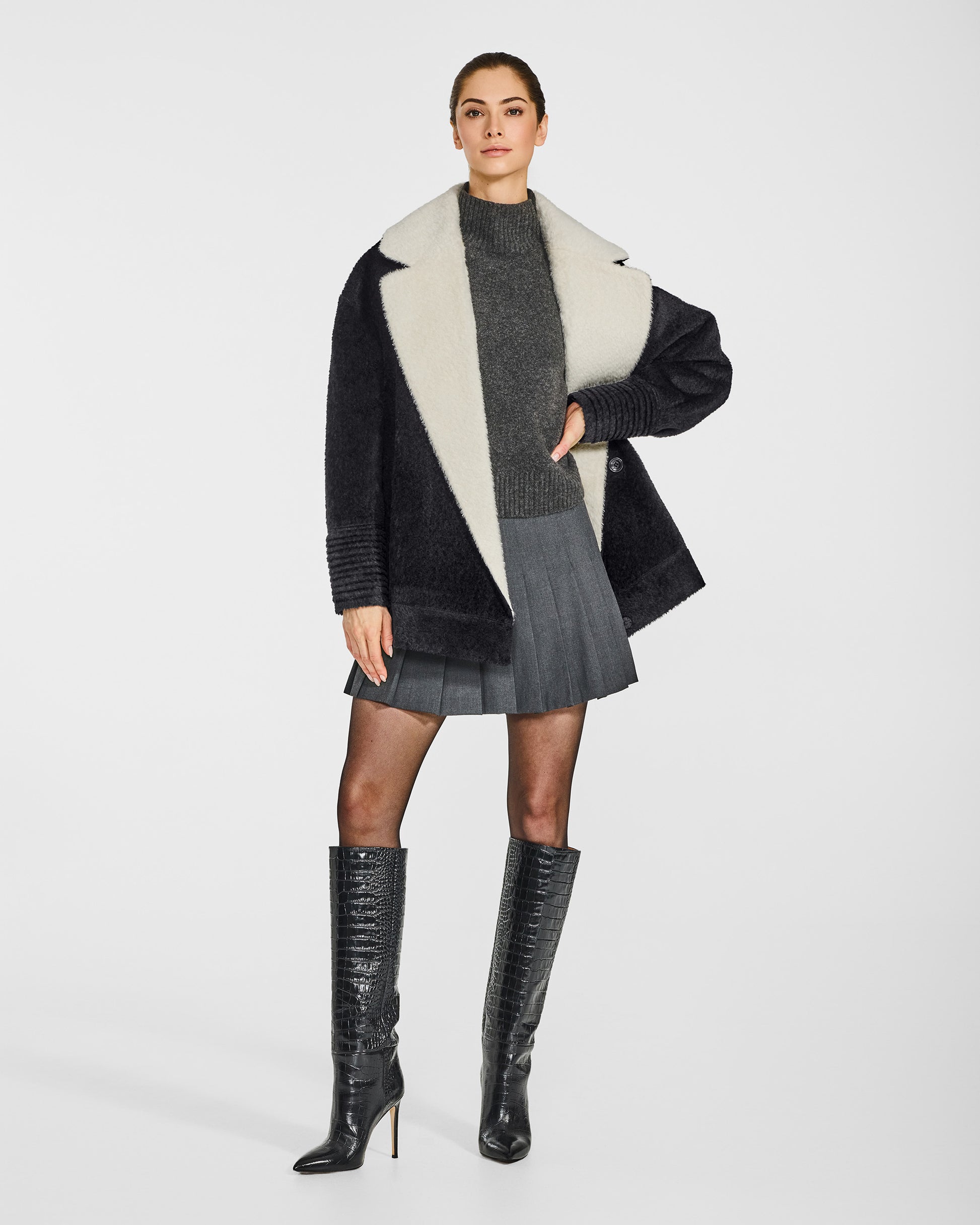 Front view of model in Sentaler black and white aviator jacket with dropped shoulders in bouclé alpaca wool, open.