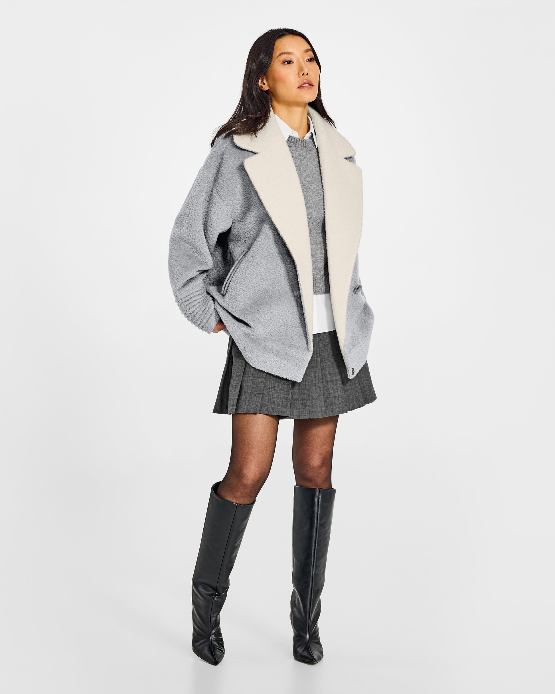 Front view of model wearing a Sentaler glacial grey aviator jacket made of bouclé alpaca wool, with dropped shoulders, worn open.