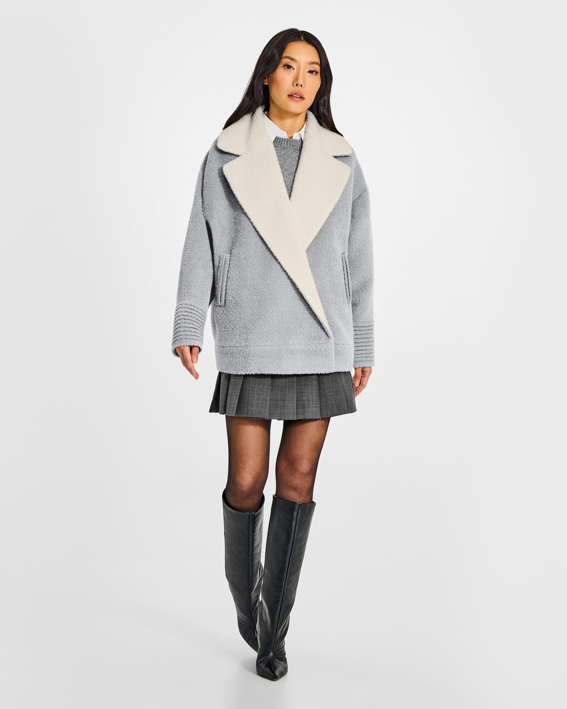 Front view of model wearing a Sentaler glacial grey aviator jacket made of bouclé alpaca wool, with dropped shoulders, worn buttoned.