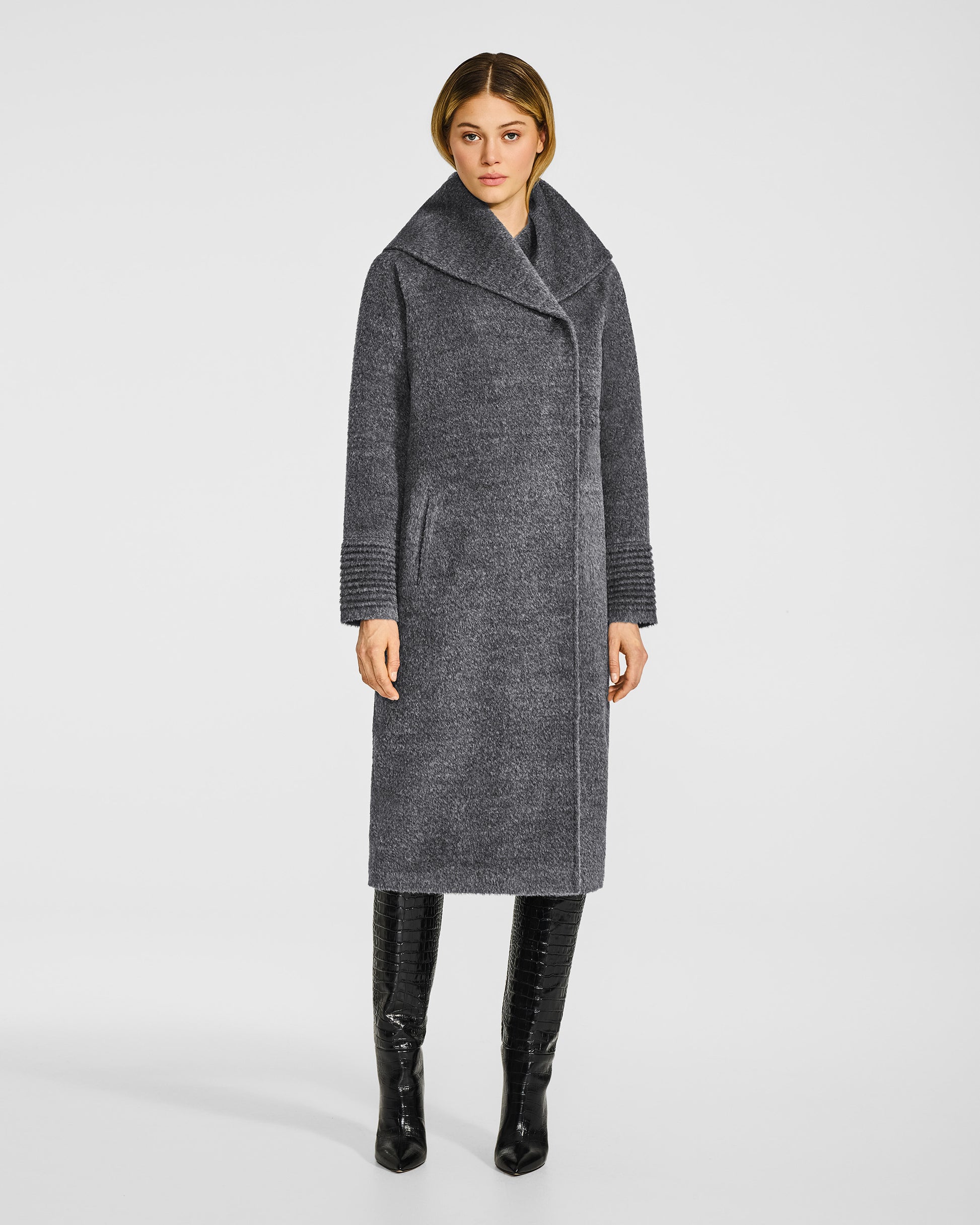 Front view of model wearing a Sentaler long grey mélange coat made of bouclé alpaca wool, with a hooded collar, buttoned.