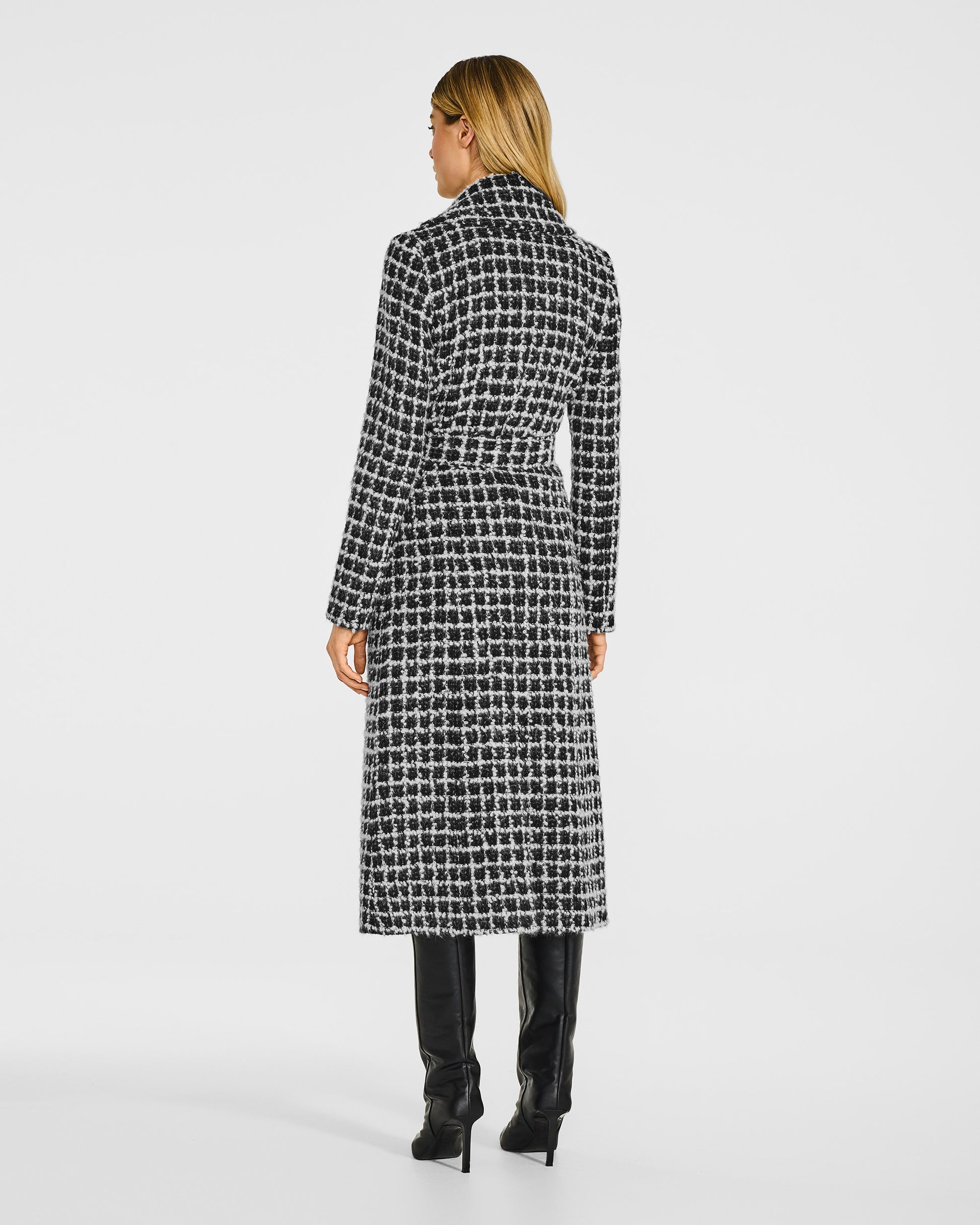 Back view of model wearing a Sentaler black check wrap coat made of suri alpaca wool, with a notched collar, worn belted.