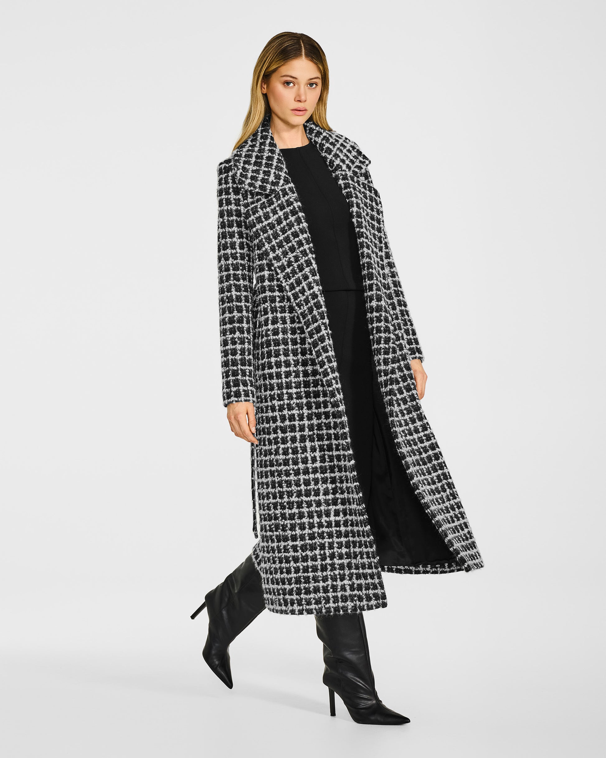 Side view of model wearing a Sentaler black check wrap coat made of suri alpaca wool, with a notched collar, worn open.