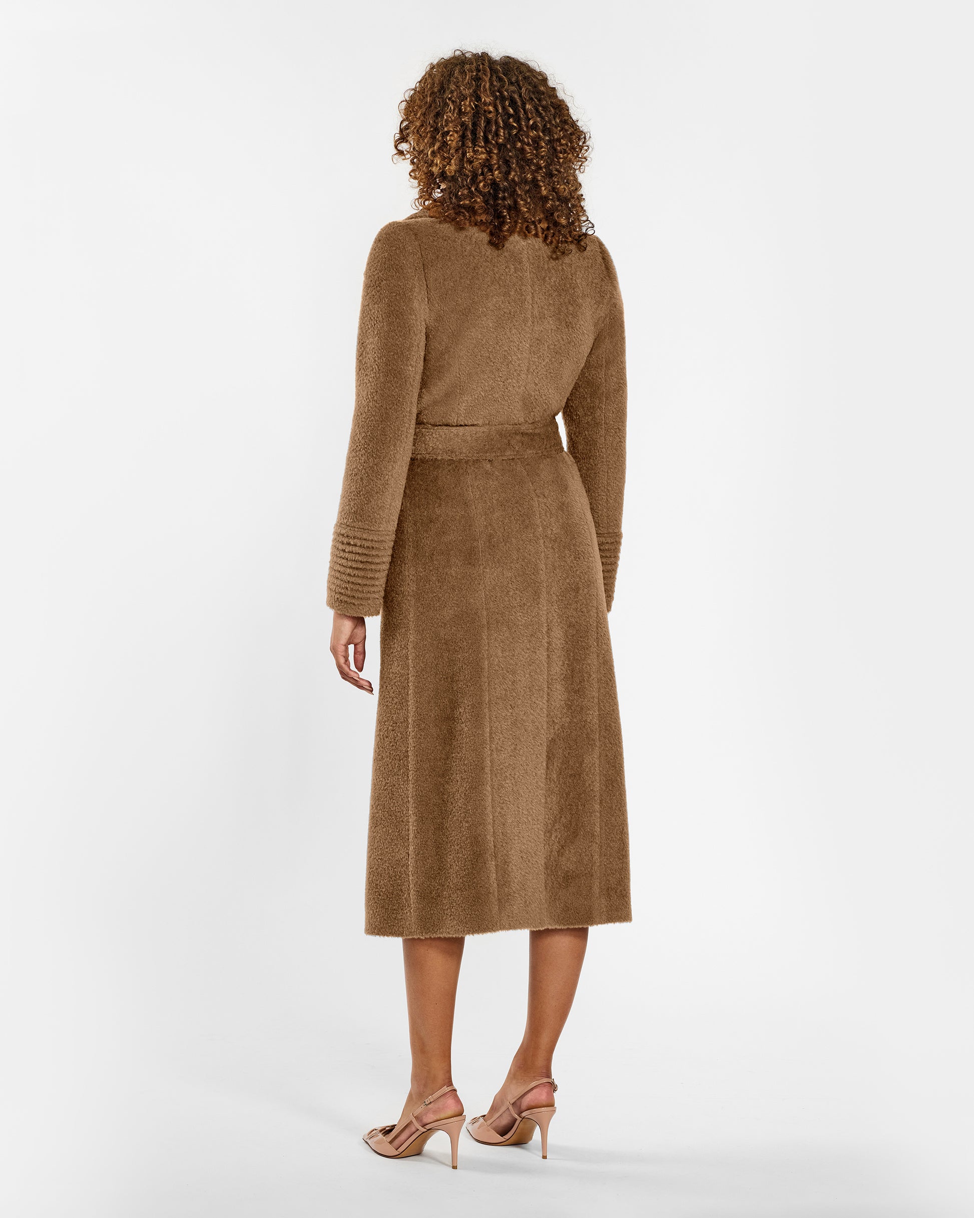 Back view of model wearing a Sentaler dark camel wrap coat made of bouclé alpaca wool, with a notched collar, worn belted.