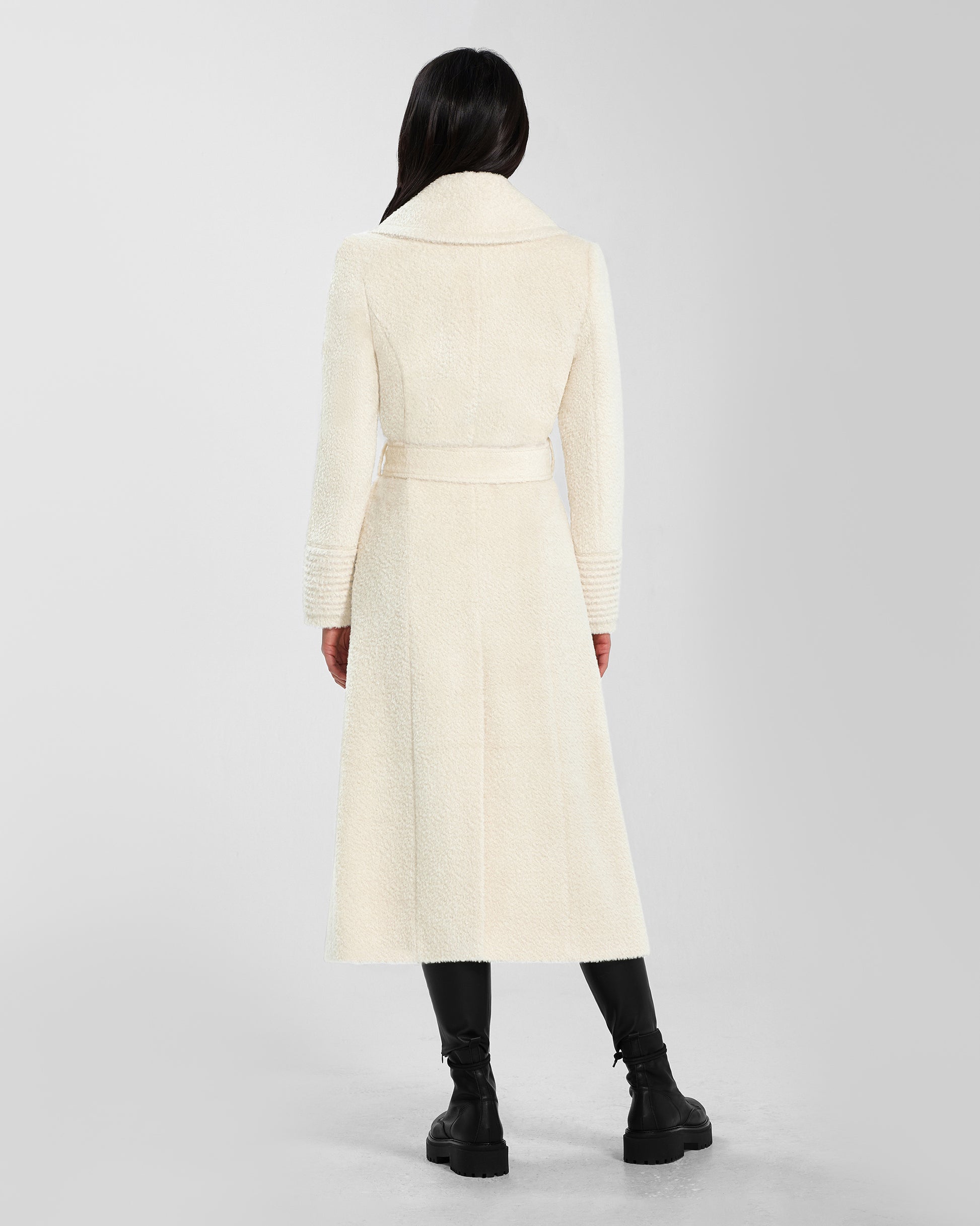 Back view of model wearing a Sentaler ivory wrap coat made of bouclé alpaca wool, with a notched collar, worn belted.