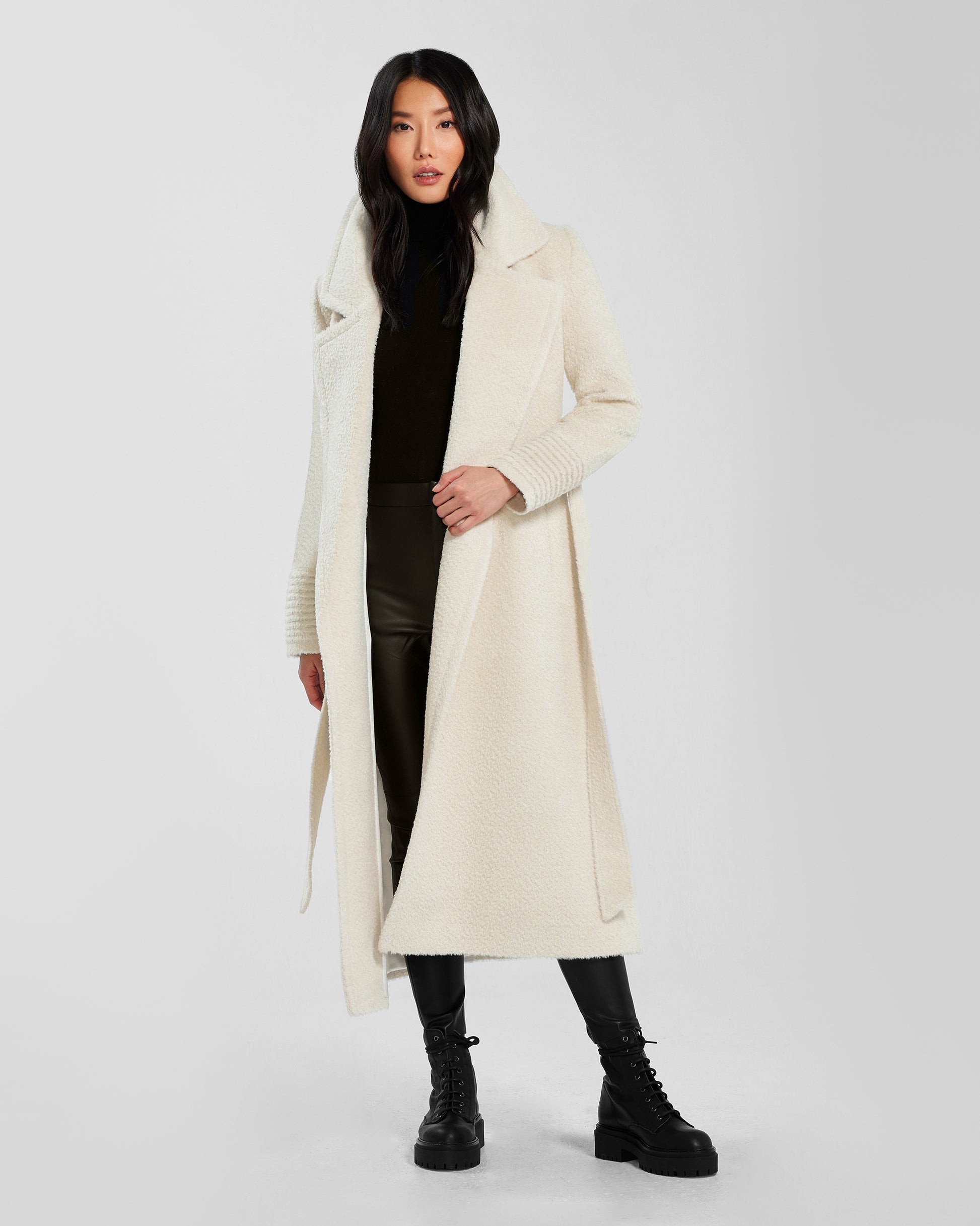 Front view of model wearing a Sentaler ivory wrap coat made of bouclé alpaca wool, with a notched collar, worn open.