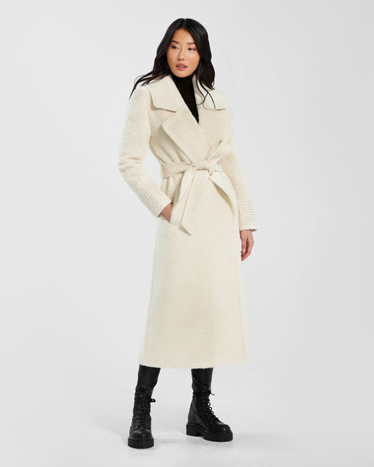 Front view of model wearing a Sentaler ivory wrap coat made of bouclé alpaca wool, with a notched collar, worn belted.