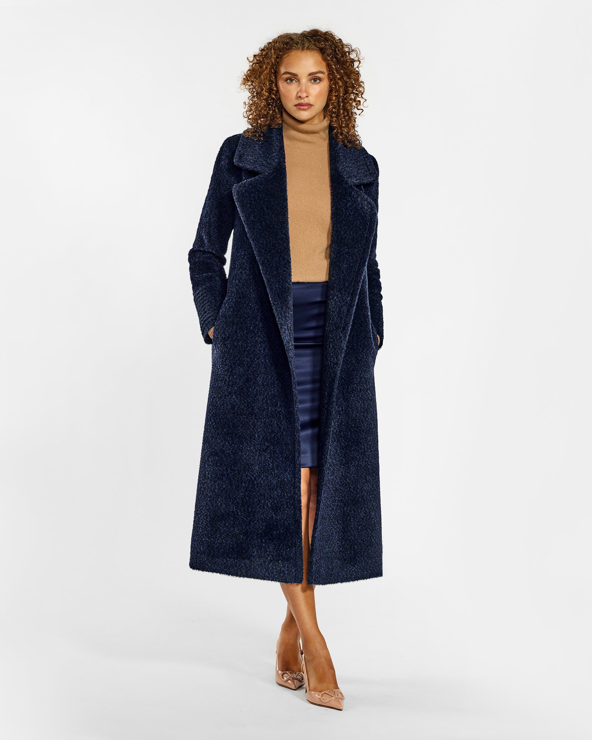 Front view of model wearing a Sentaler midnight blue wrap coat made of bouclé alpaca wool, with a notched collar, worn open.