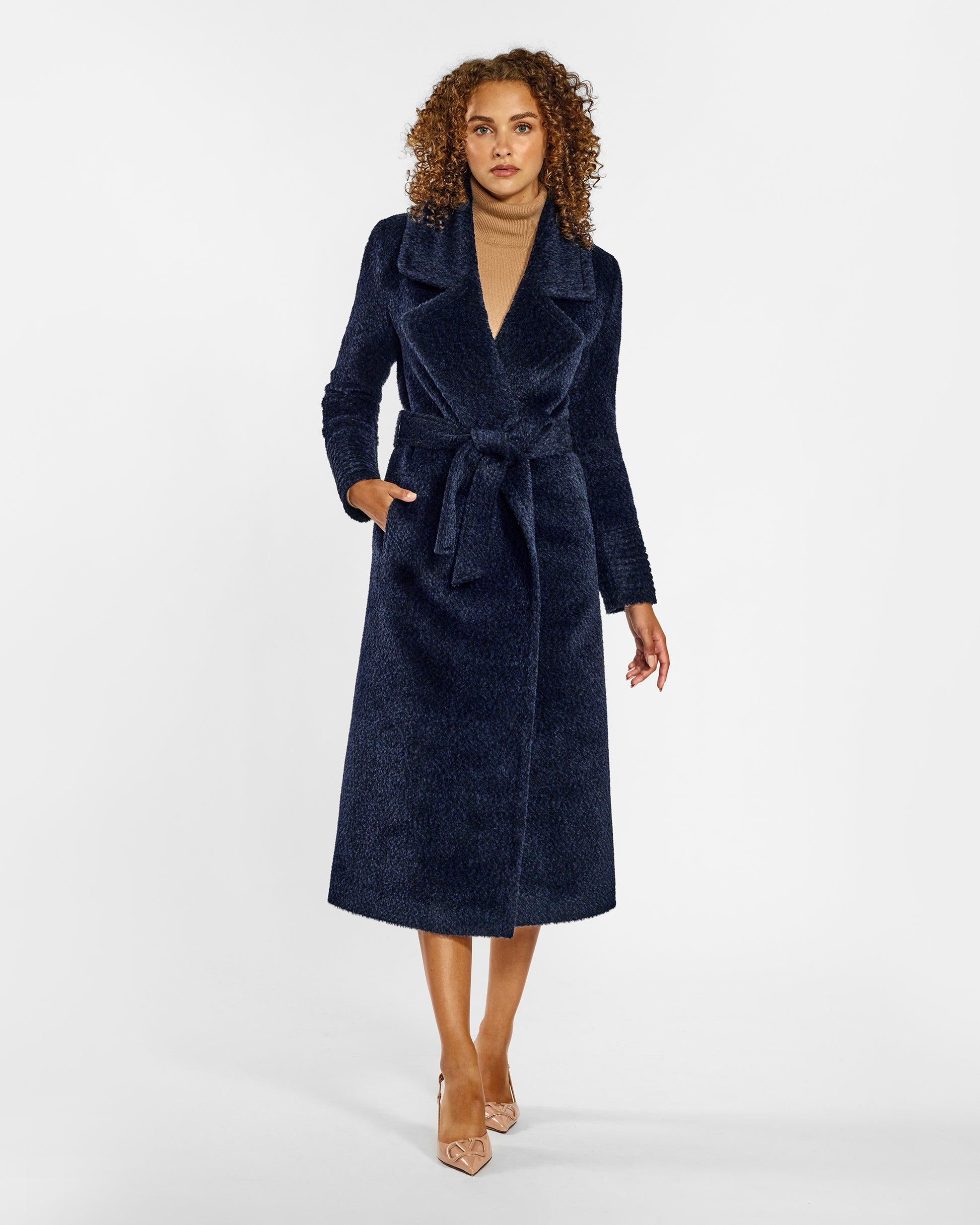 Front view of model wearing a Sentaler midnight blue wrap coat made of bouclé alpaca wool, with a notched collar, worn belted.
