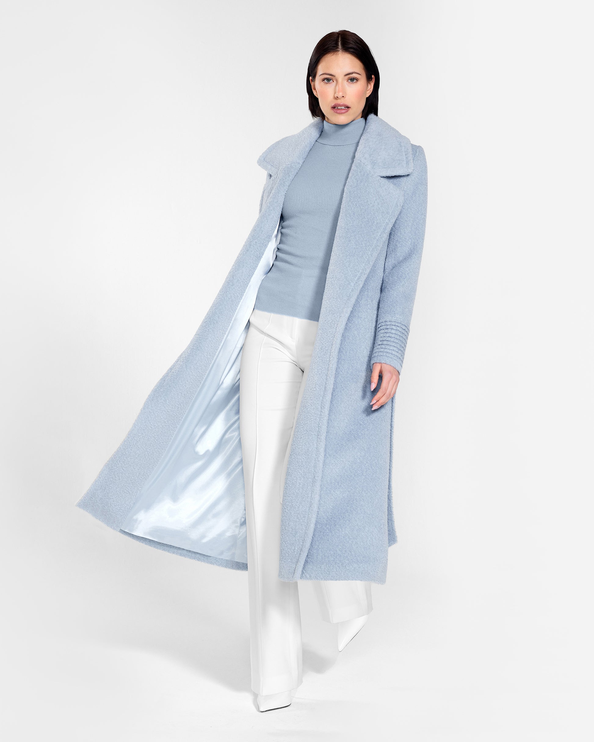 Front view of model wearing a Sentaler powder blue wrap coat made of bouclé alpaca wool, with a notched collar, worn open.